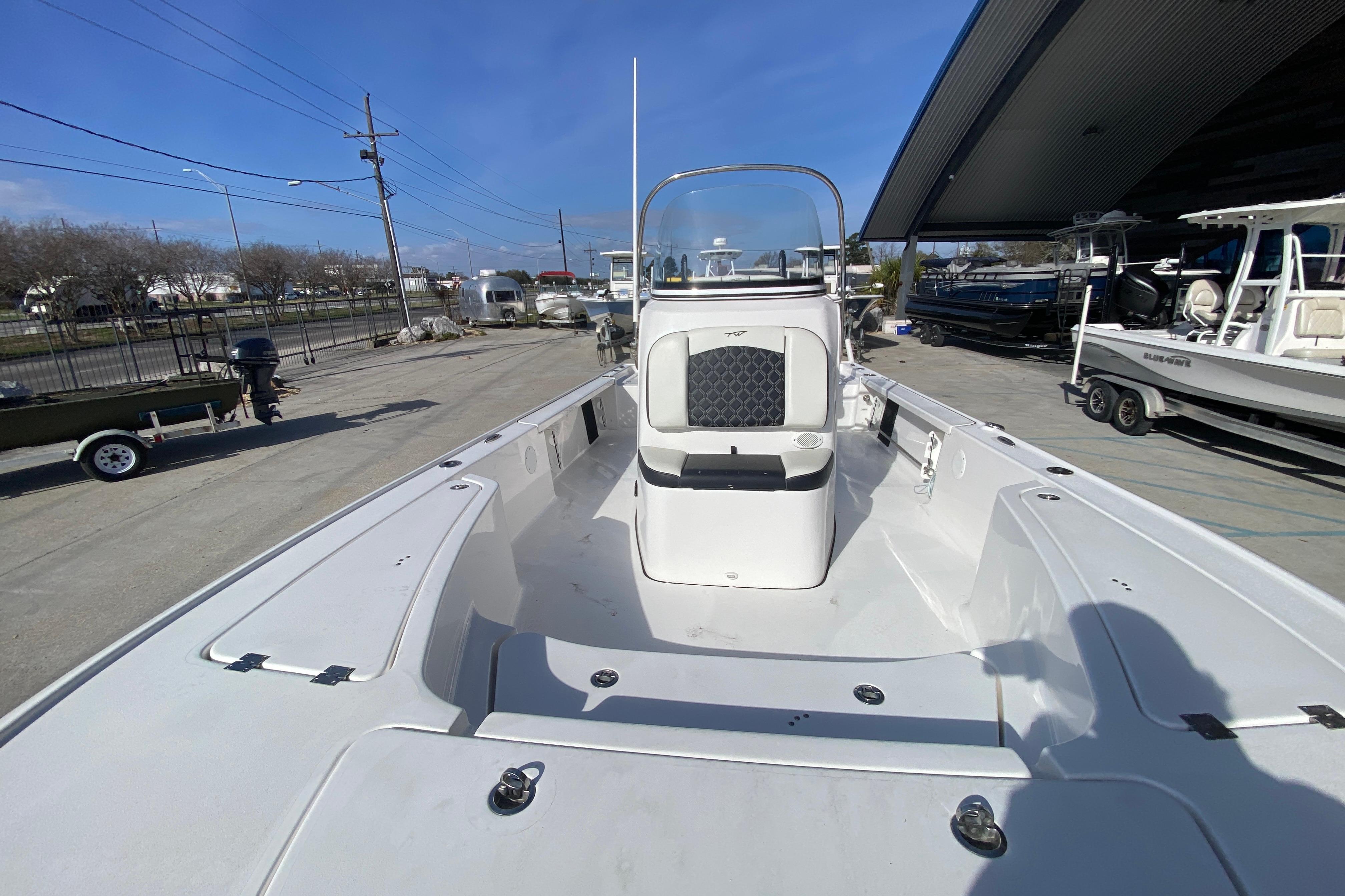 2023 Tidewater 2410 Bay Max boat, spacious deck, sleek design, parked outdoors.