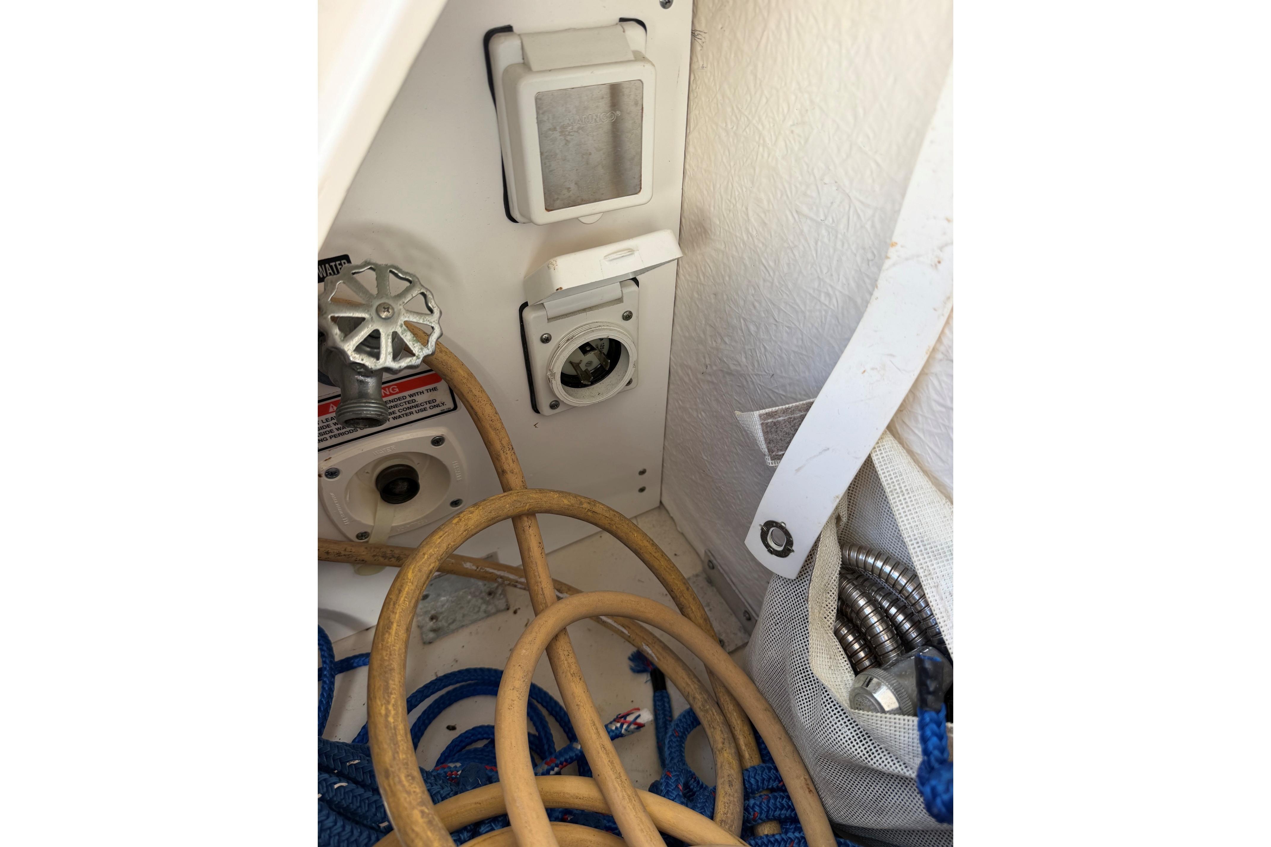 Interior view of a 2000 Sea Ray 240 Sundancer boat showing utility connections and hoses.