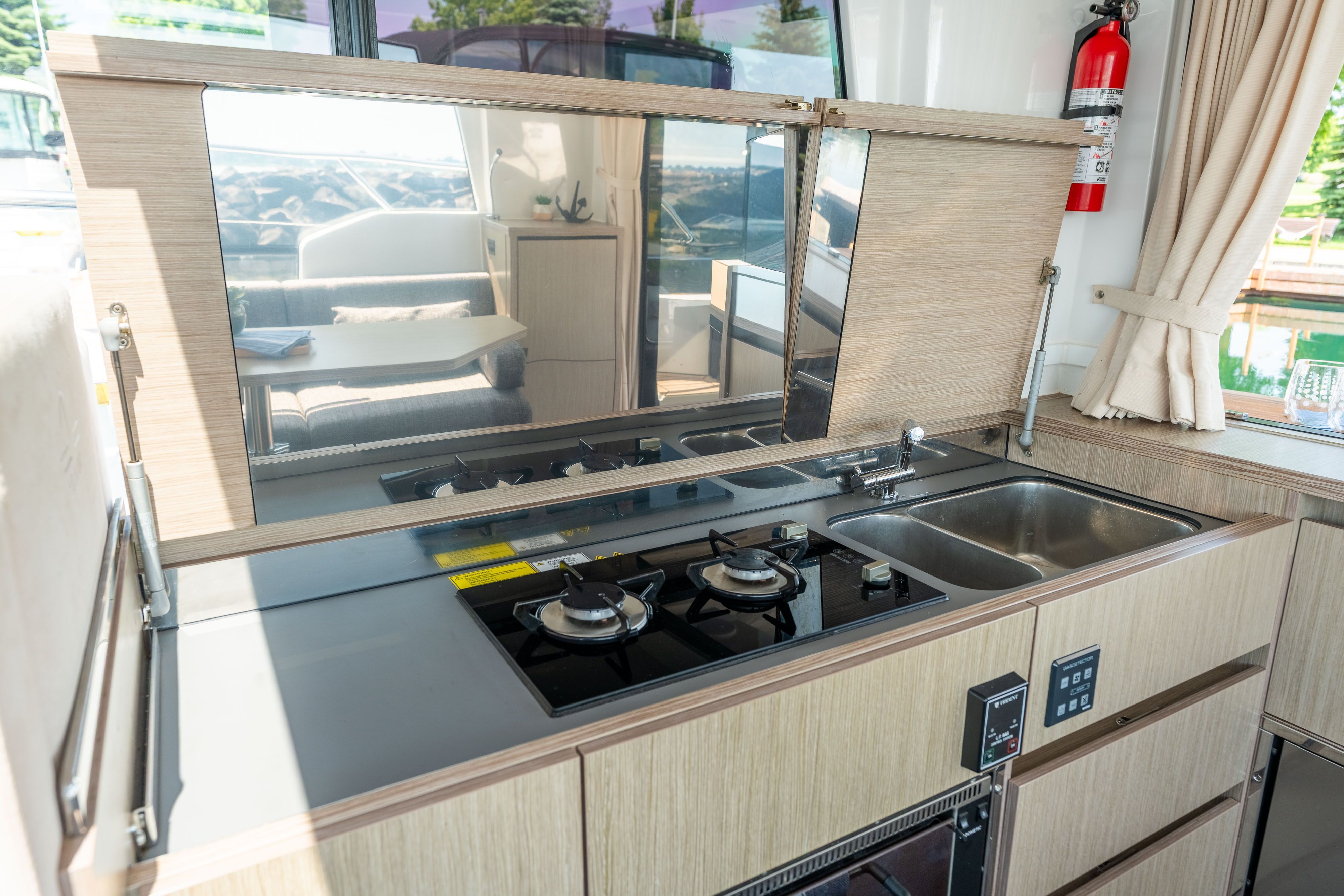Sealine C335V kitchen with stove, sink, and wood paneling.