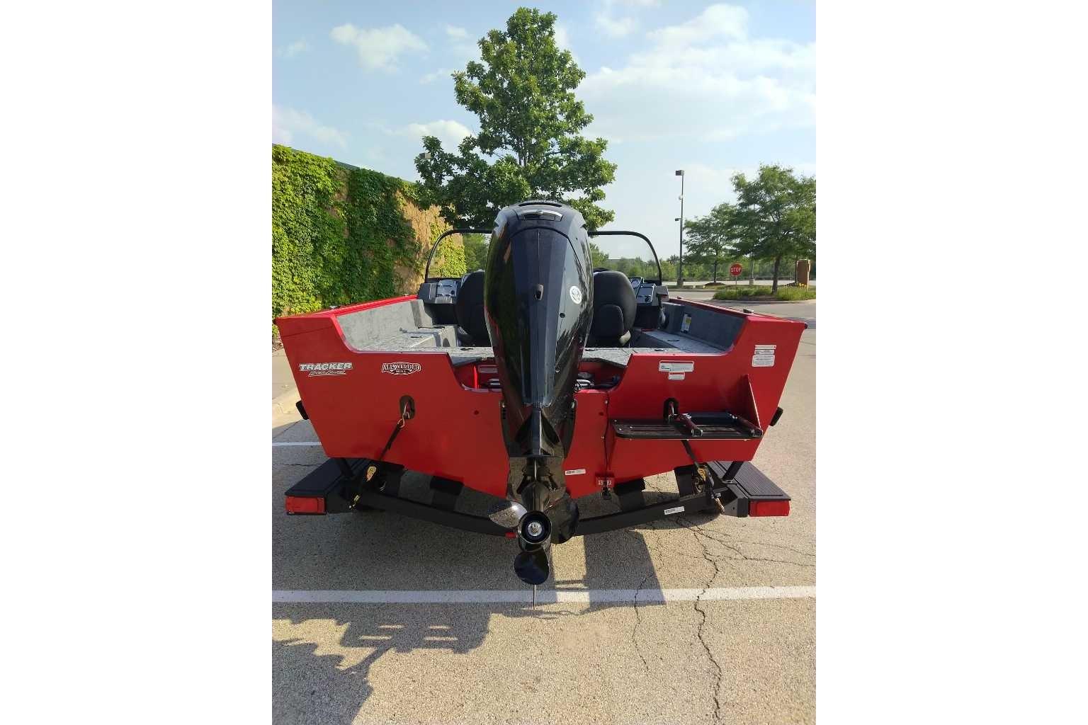 2026 Tracker Pro Guide V-175 WT boat, red exterior, parked outdoors.