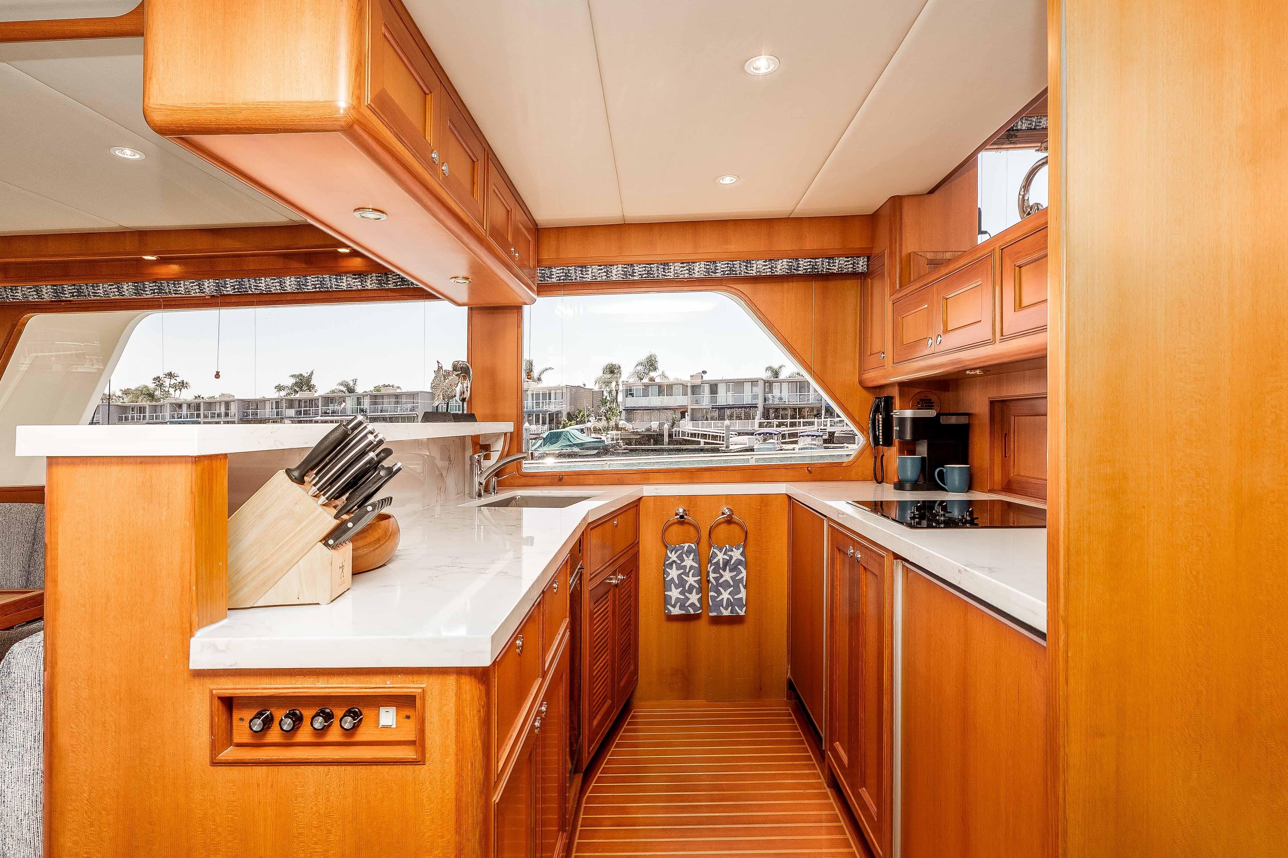 Luxurious 2005 Offshore Yachts 54 Pilothouse kitchen with wood cabinetry and modern appliances.