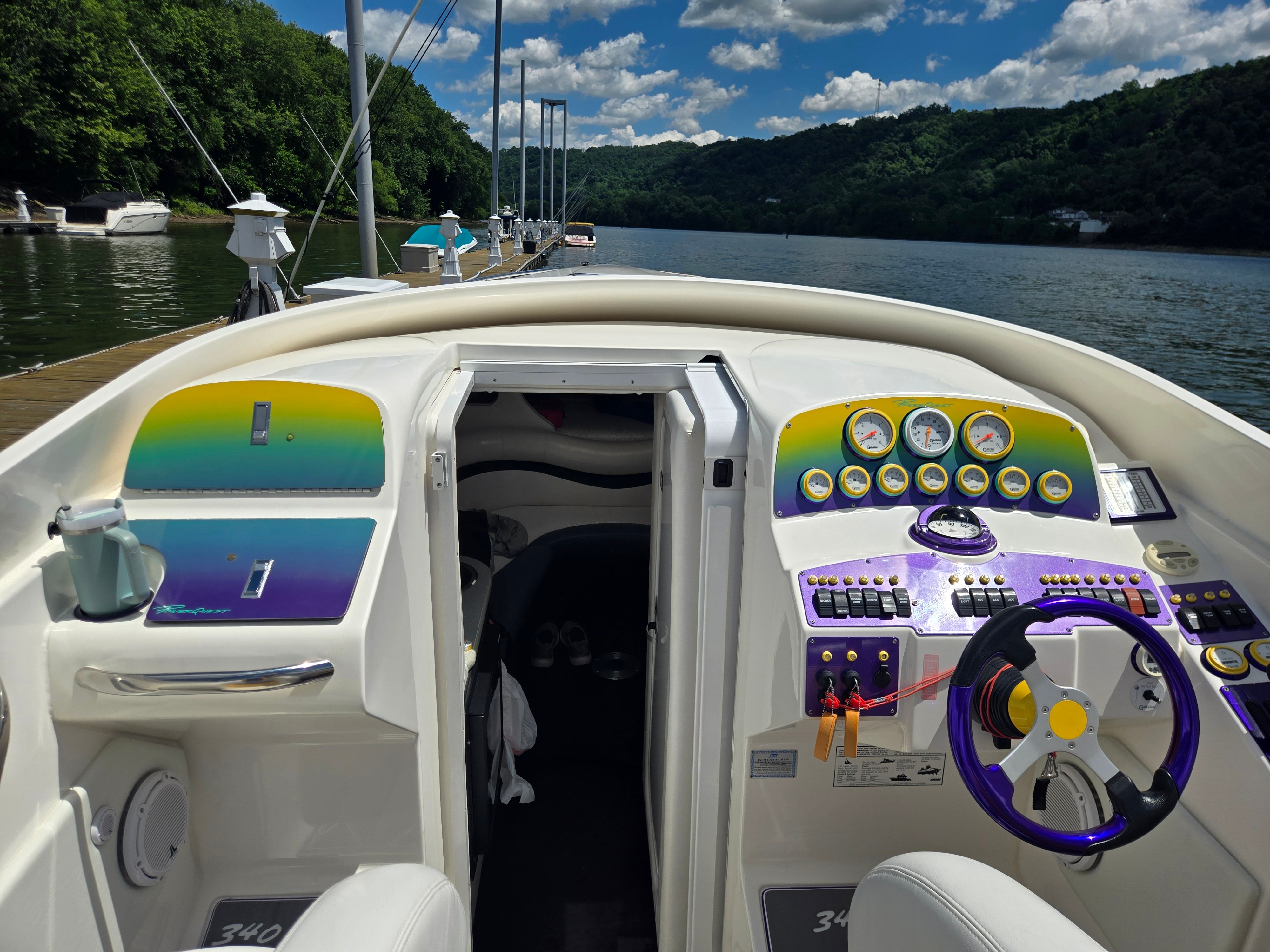 The cockpit of a Powerquest 340 Vyper boat with colorful dashboard and steering wheel.
