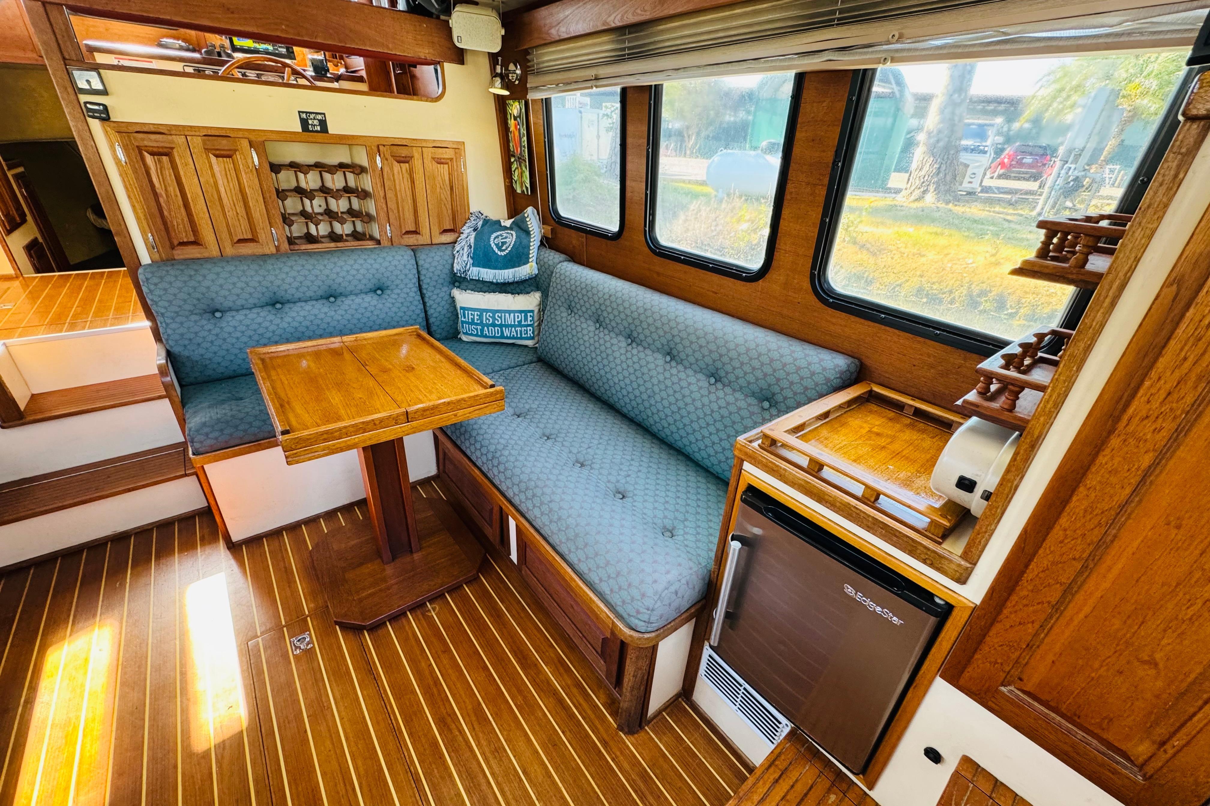 Interior of a 1996 Nordic Tug 32 with cozy seating and wooden accents.