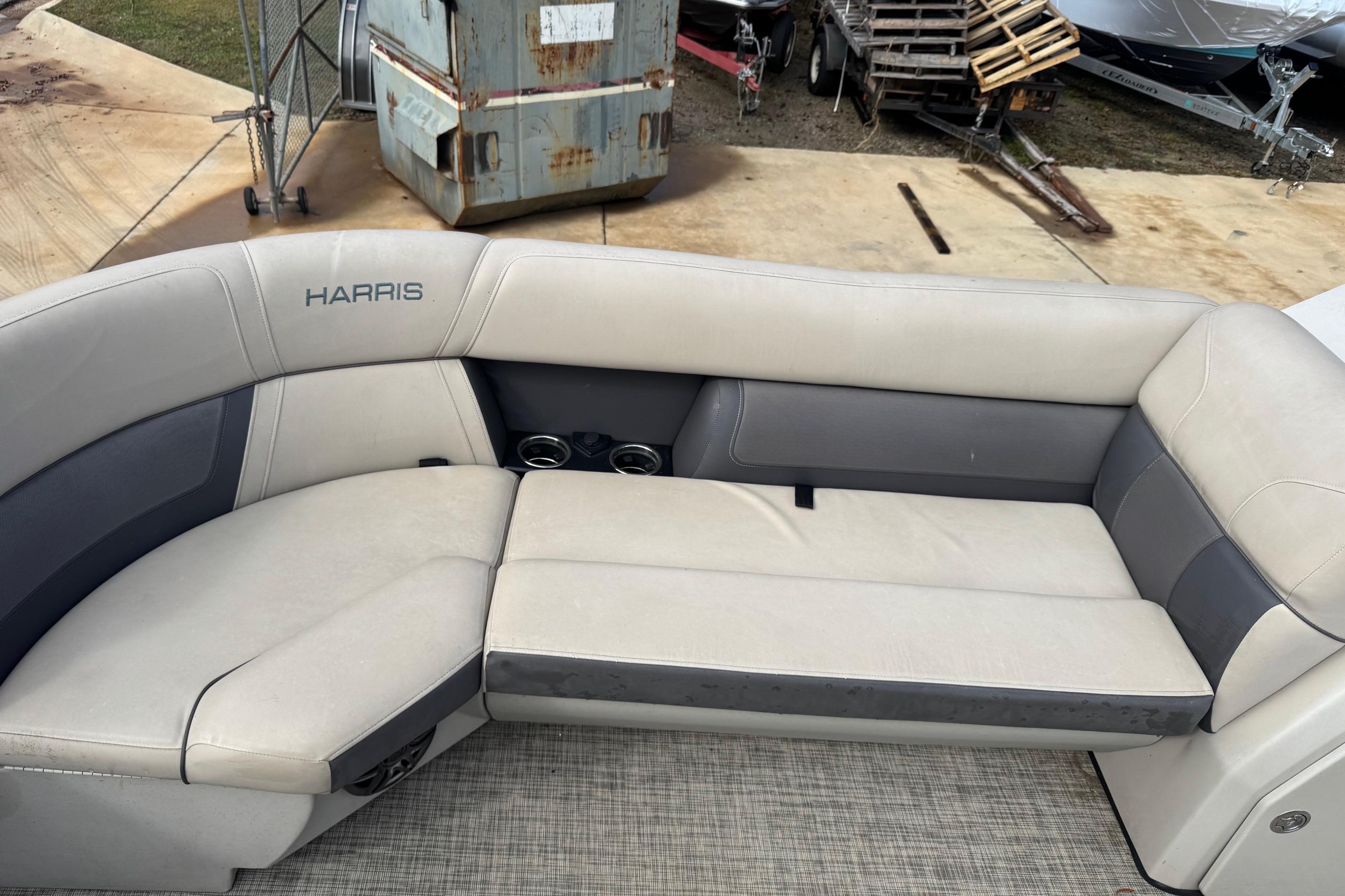 2023 Harris Cruiser 230 boat interior with beige seating and cup holders.