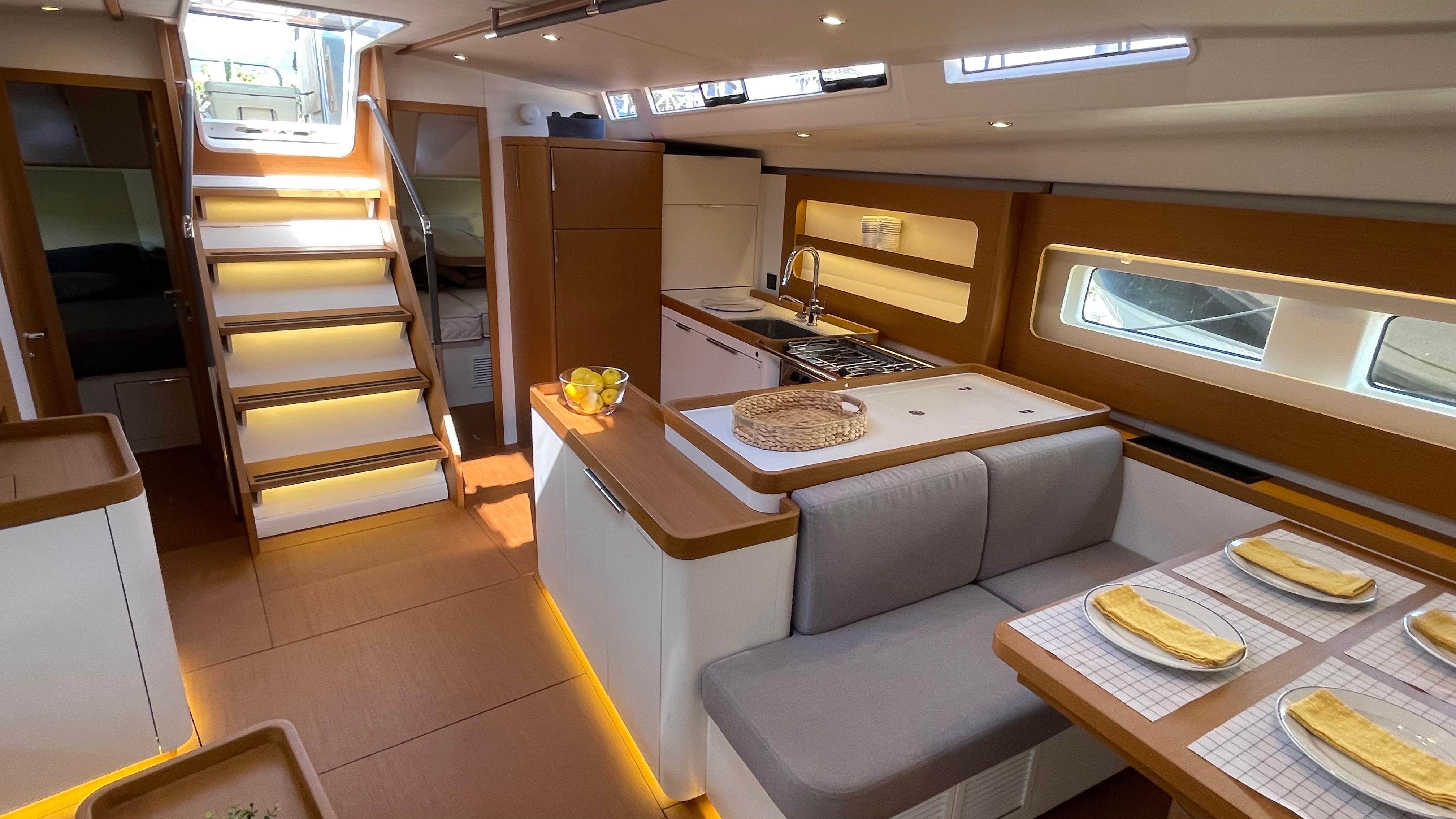 Luxurious interior of 2020 Beneteau First 53 yacht with modern kitchen and dining area.