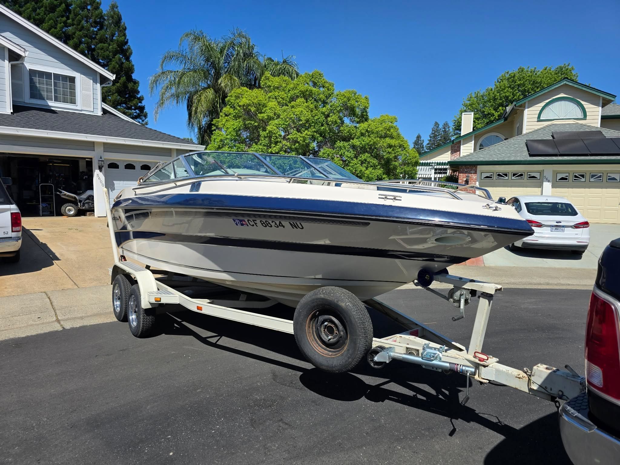1996 Mariah Talari boat on trailer parked in front of house.