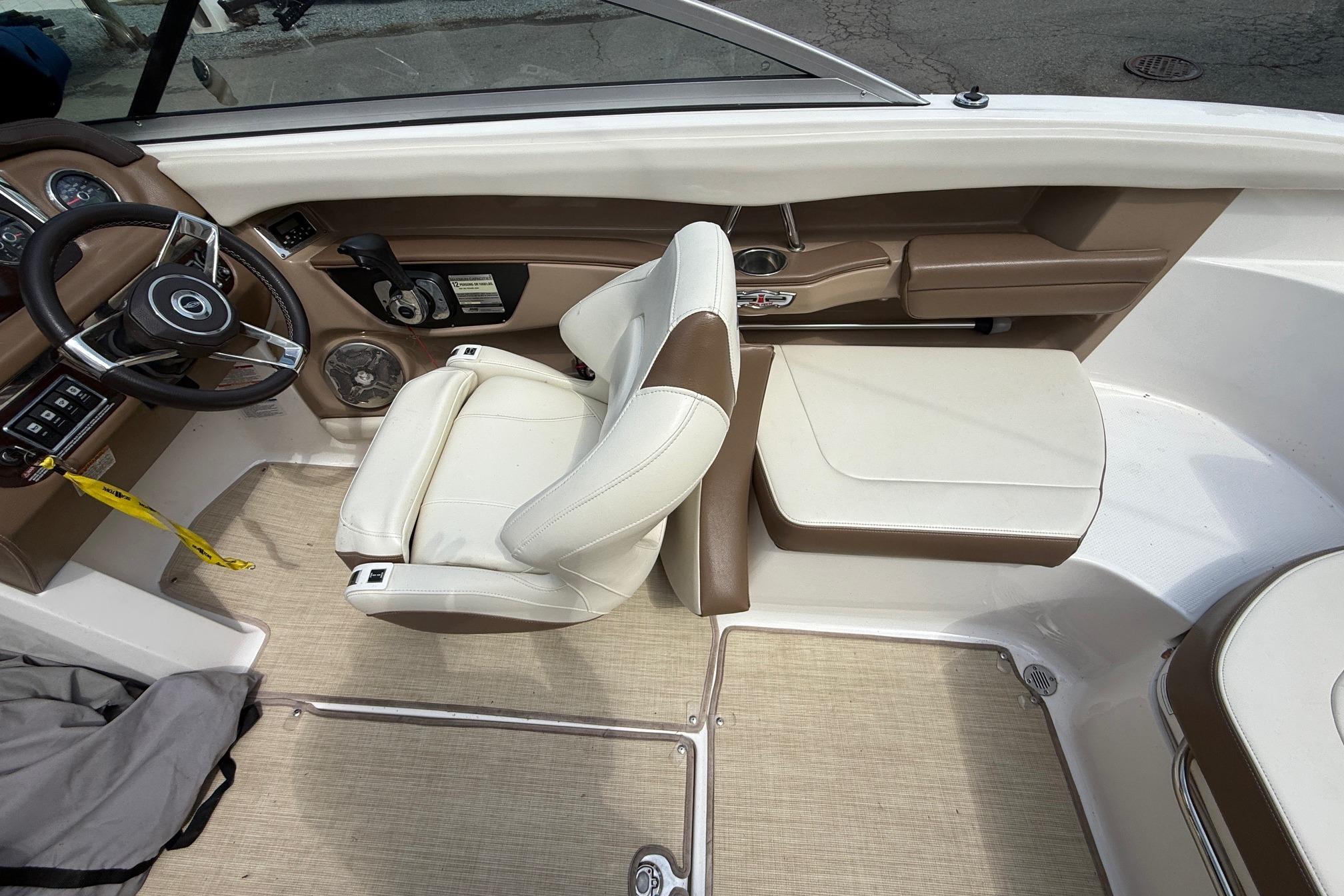 Interior of 2016 Chaparral 226 SSi Wide Tech boat with beige seating and steering wheel.