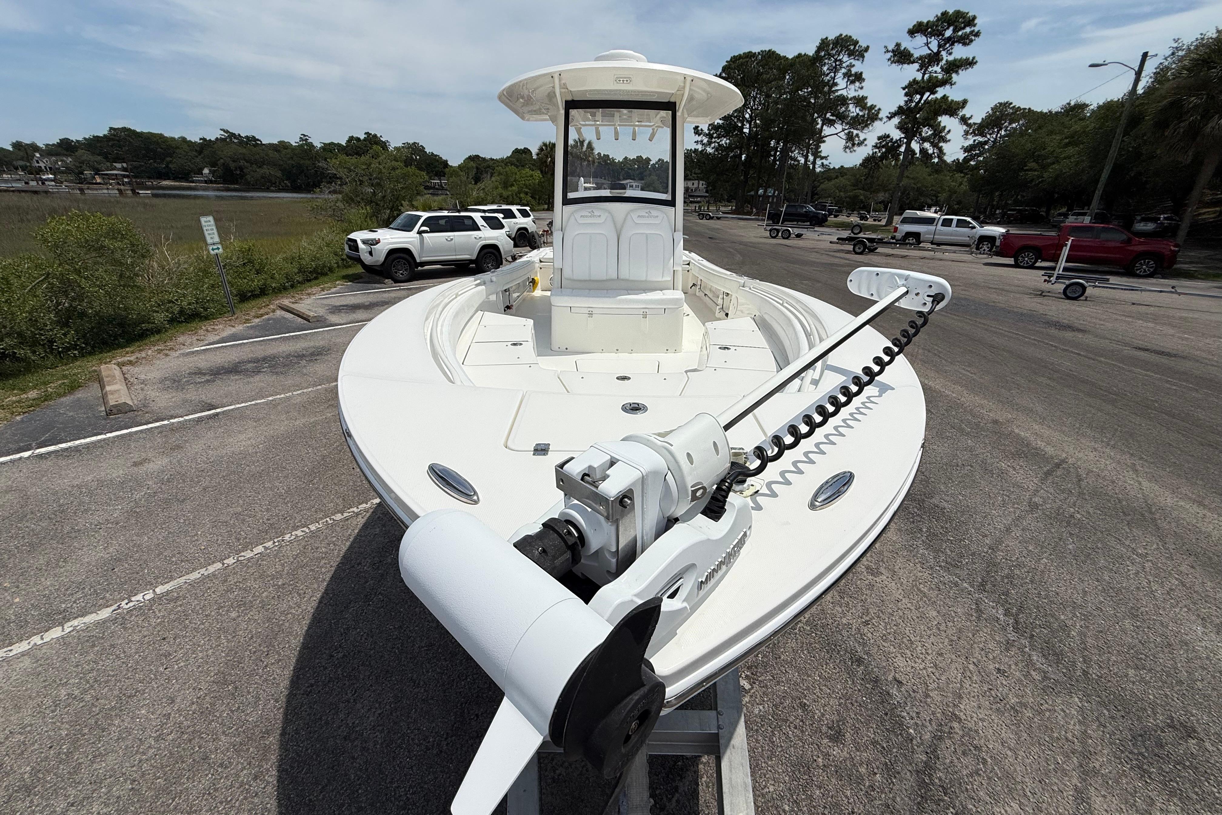 2019 Regulator 26XO boat on trailer in parking lot, surrounded by trees and vehicles.