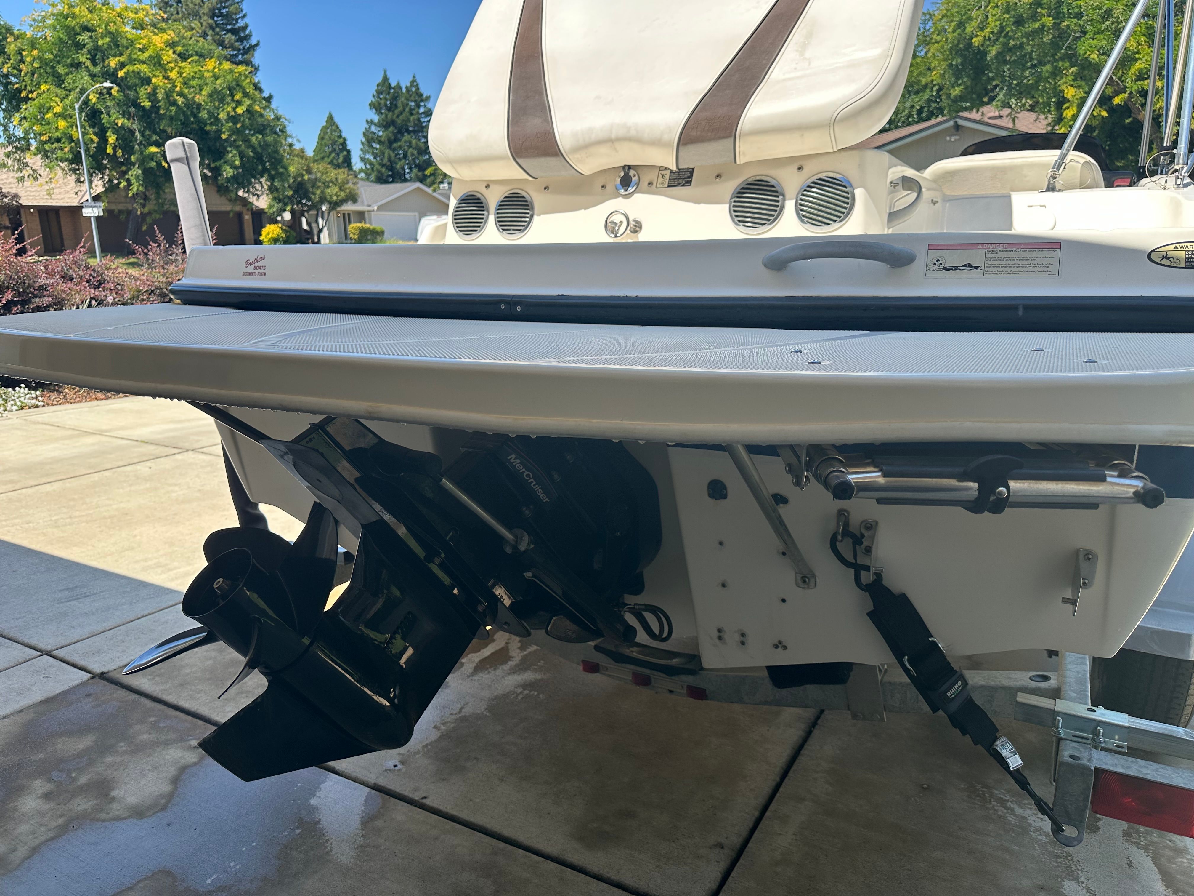 The rear of a Bayliner boat with motor and propeller, parked on a trailer.