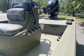 2026 Tracker Grizzly 1860 CC boat with seating and motor, parked outdoors.