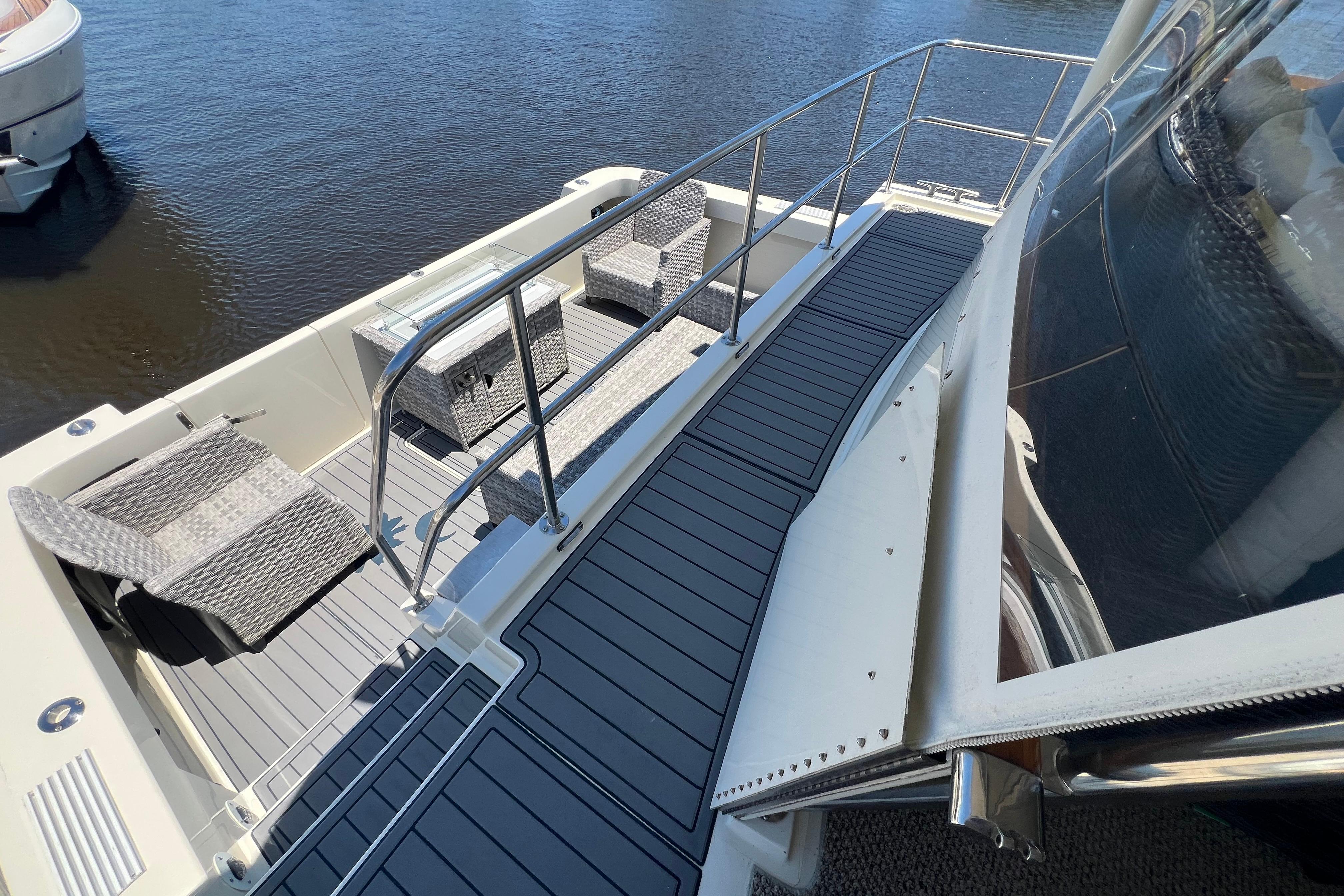 1987 Hatteras 70 Cockpit Motor Yacht deck with seating, overlooking calm water.