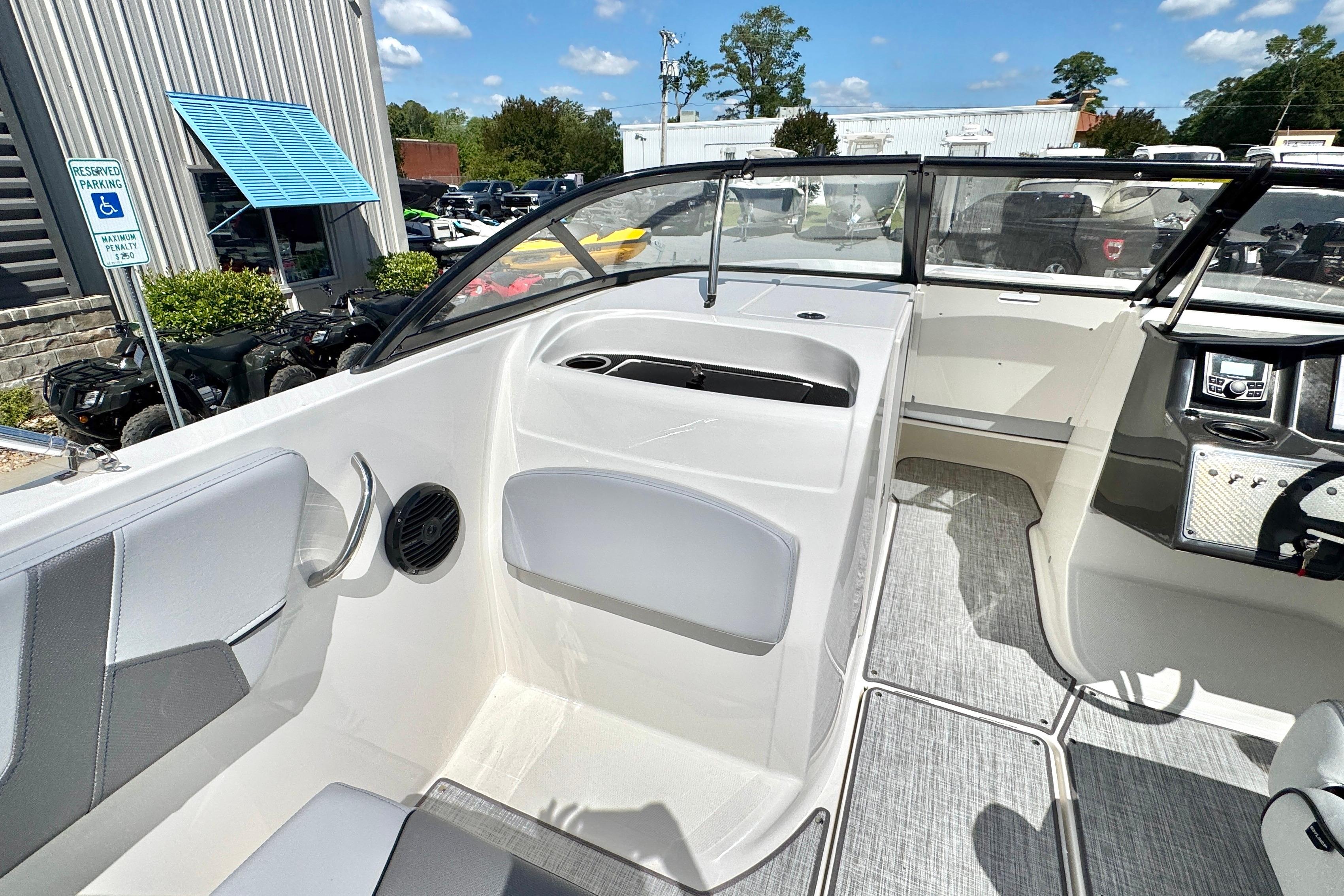 2026 Bayliner VR6 Bowrider OB interior with modern seating and dashboard, parked outdoors.