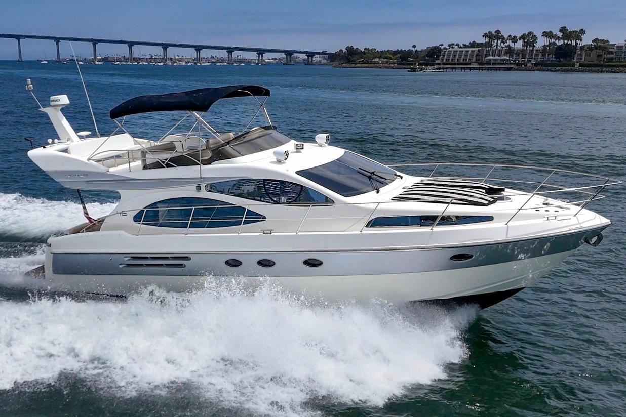 2004 Azimut 46 yacht cruising on open water with bridge in background.