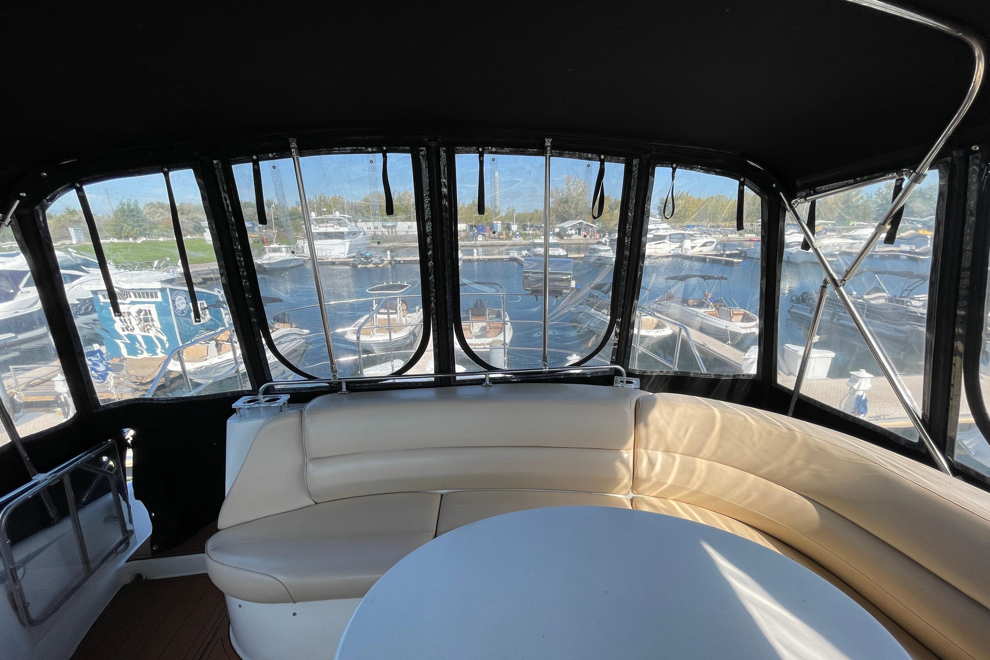 Interior view of 2002 Carver 570 Voyager Pilothouse with marina backdrop.
