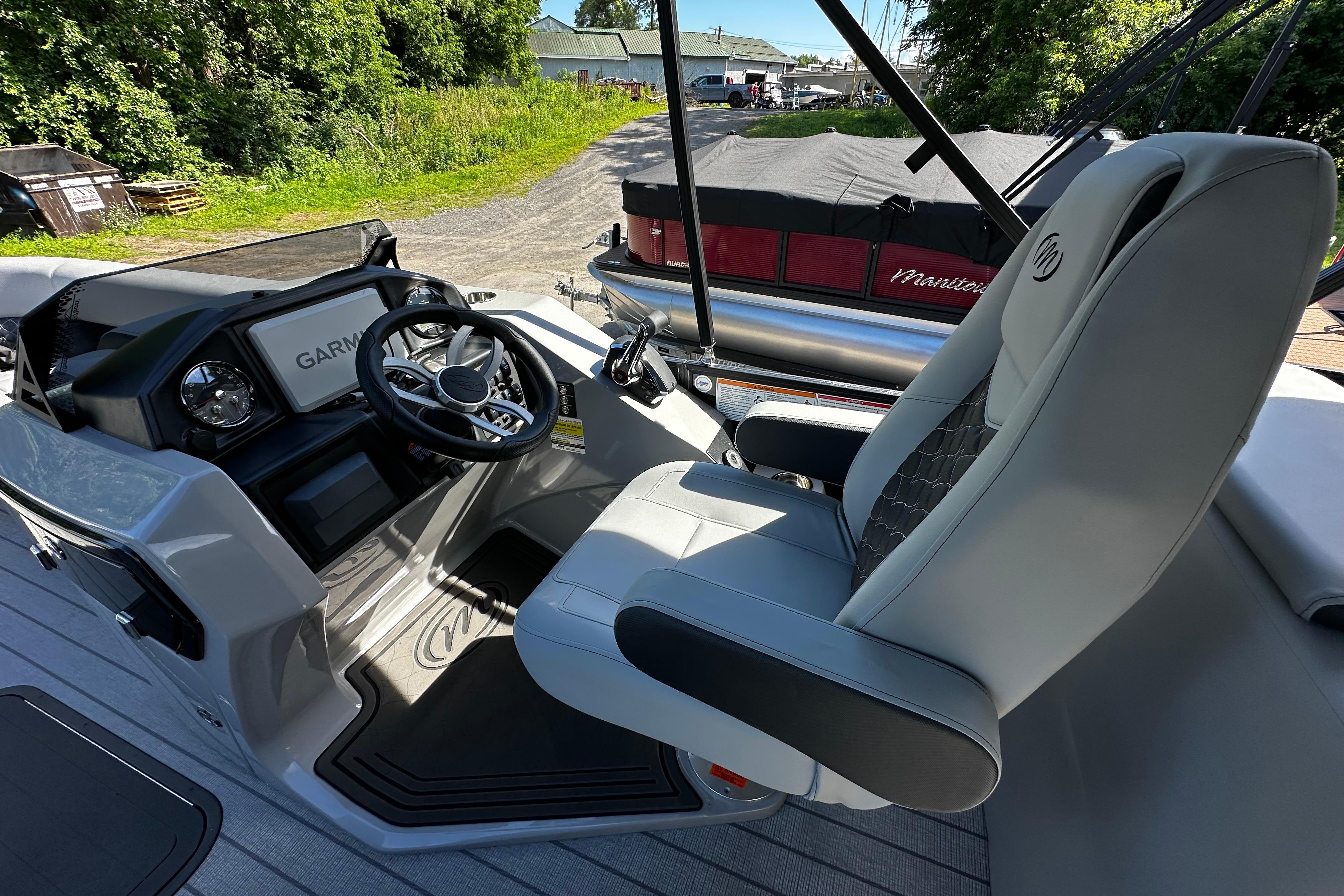 2027 Manitou 25 Encore RF boat interior with Garmin navigation and luxurious captain's chair.