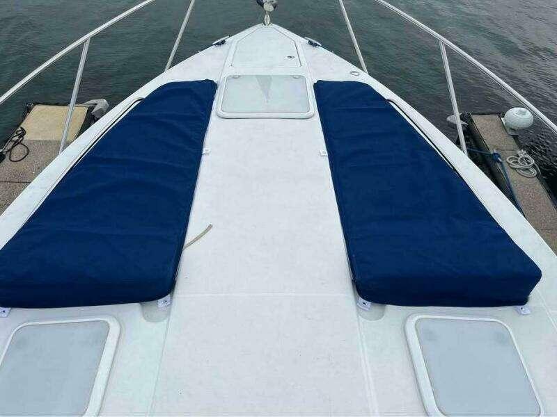 2007 Formula 31 PC boat deck with blue cushions, docked by the water.