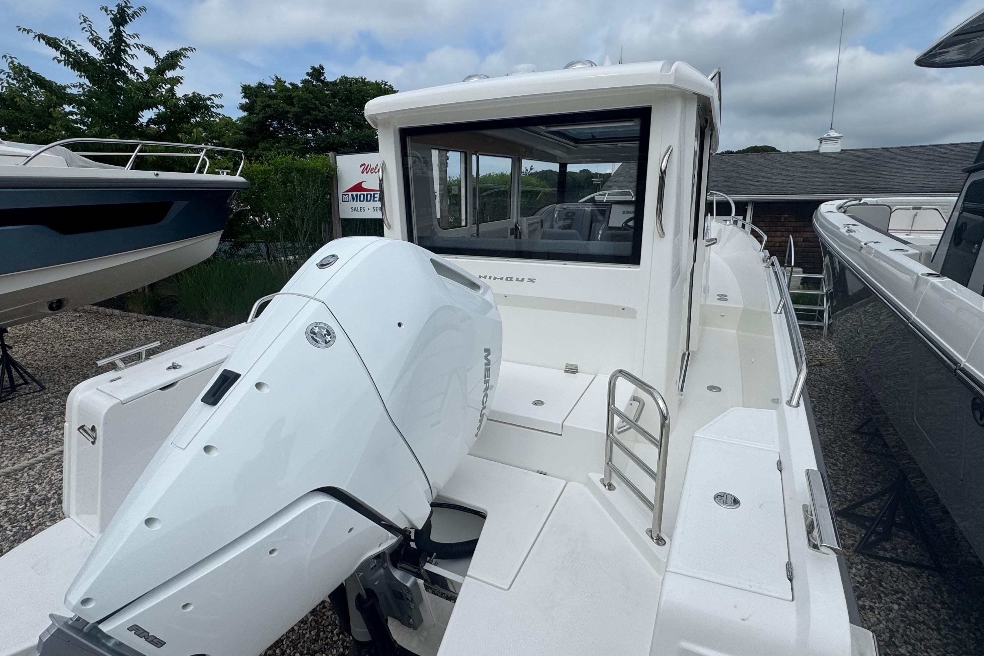 The image shows a 2026 Nimbus Commuter 9 boat with a large outboard motor.