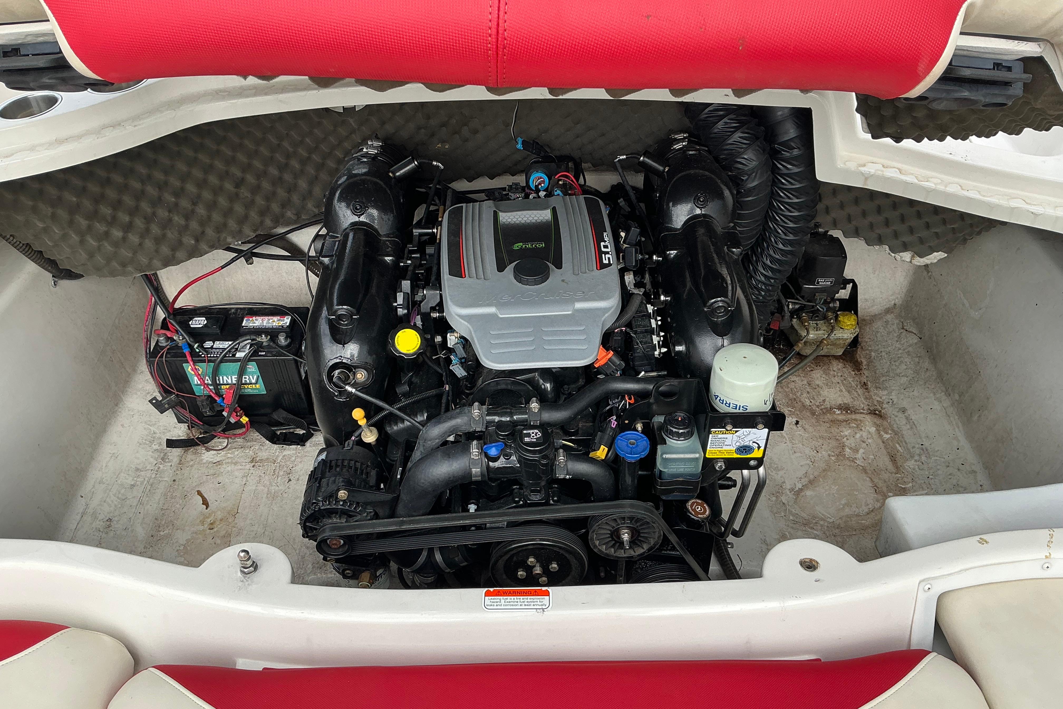 Engine compartment of a 2014 Tahoe Q7i boat, featuring a 5.0L engine and battery.