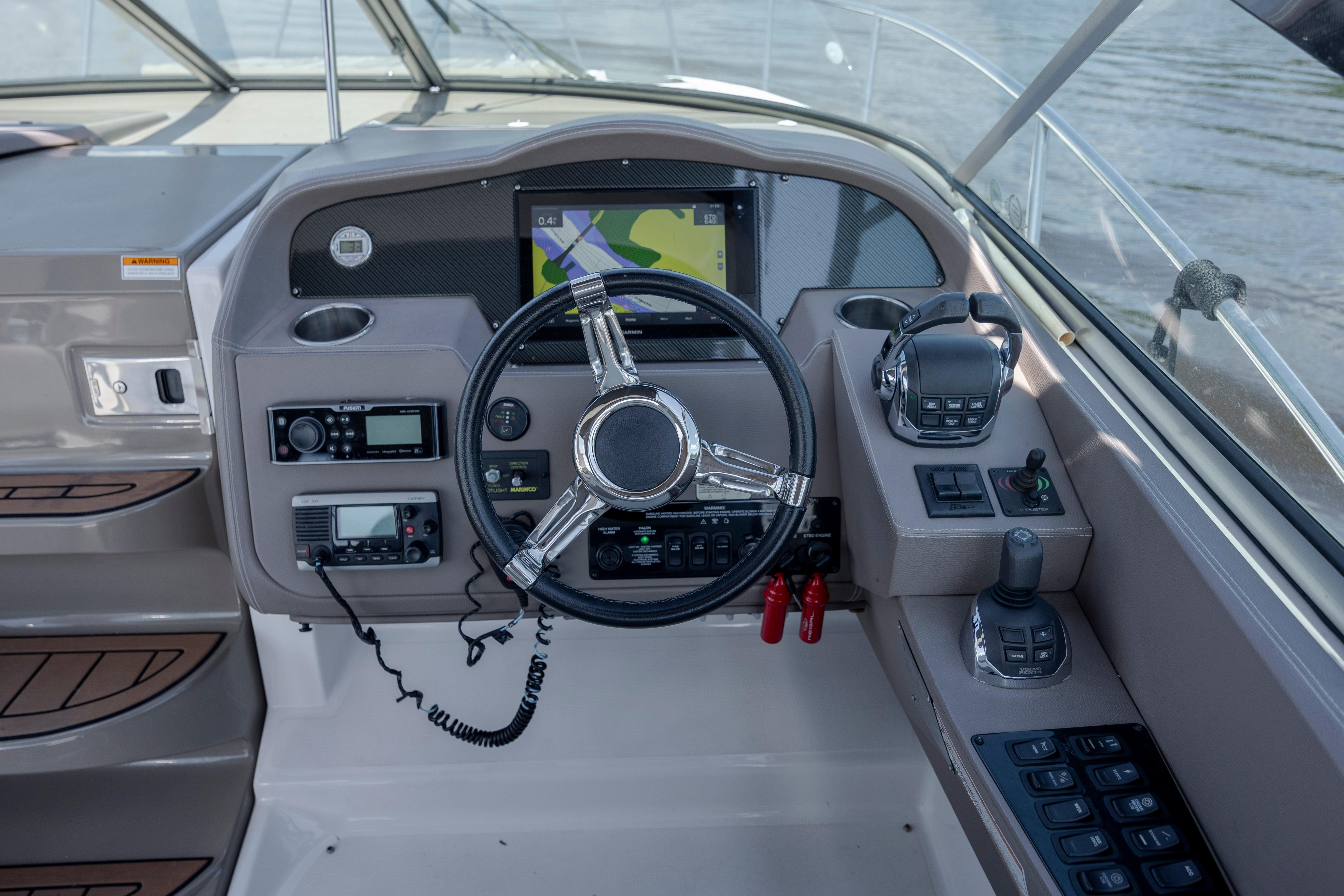 Cockpit of 2017 Regal 32 Express boat with steering wheel and navigation controls.