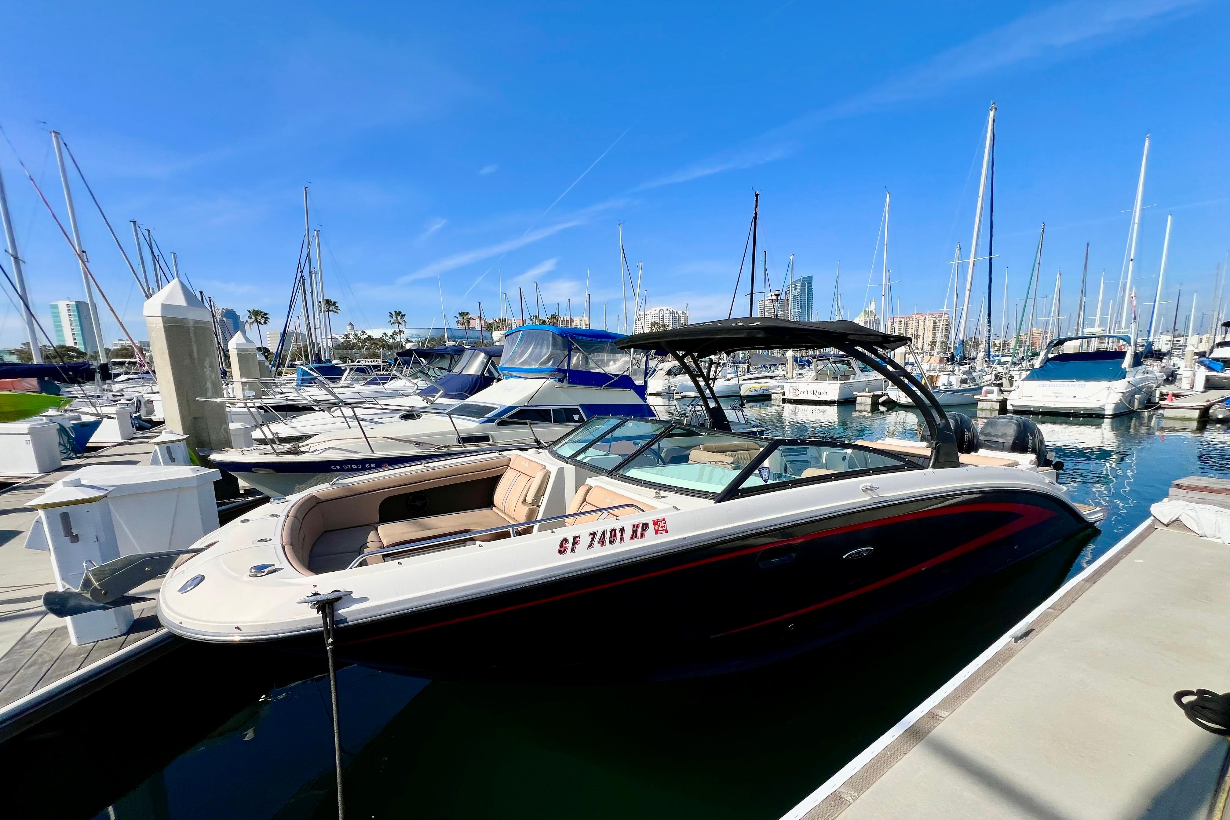 2016 Sea Ray 290 Sundeck Outboard docked at a marina under clear blue skies.