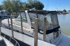 2000 Rinker Fiesta Vee 310 boat docked at a marina, featuring a covered cockpit.