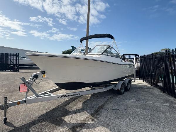 2020 Cobia 220 Dual Console boat on trailer, parked outdoors under a clear sky.