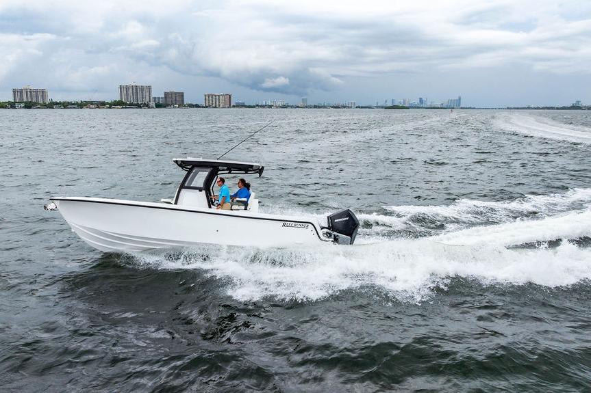 2027 Reef Runner 280 boat cruising on open water with city skyline in background.