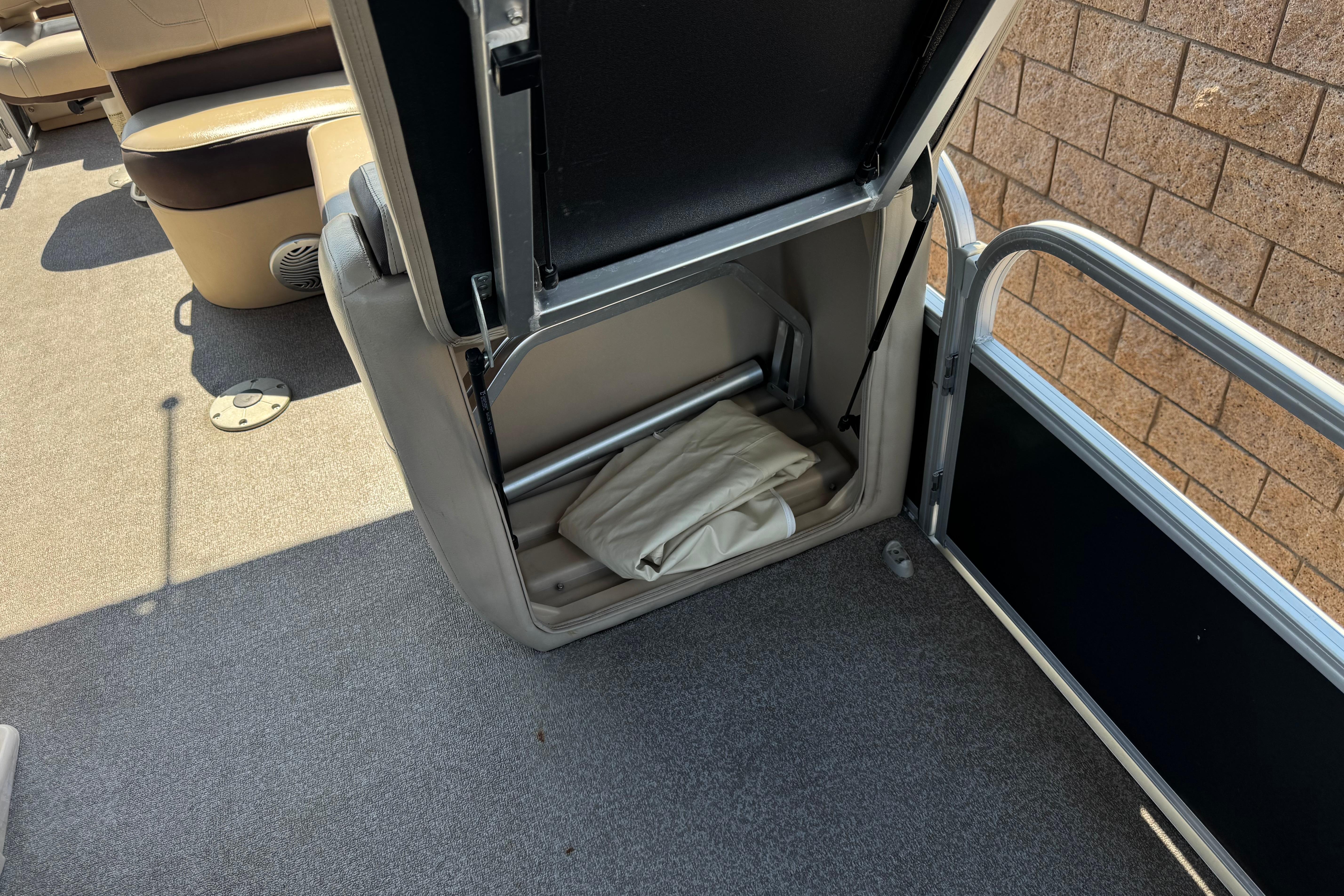 Open storage compartment on 2018 Sun Tracker SportFish 22 DLX boat, revealing interior space.