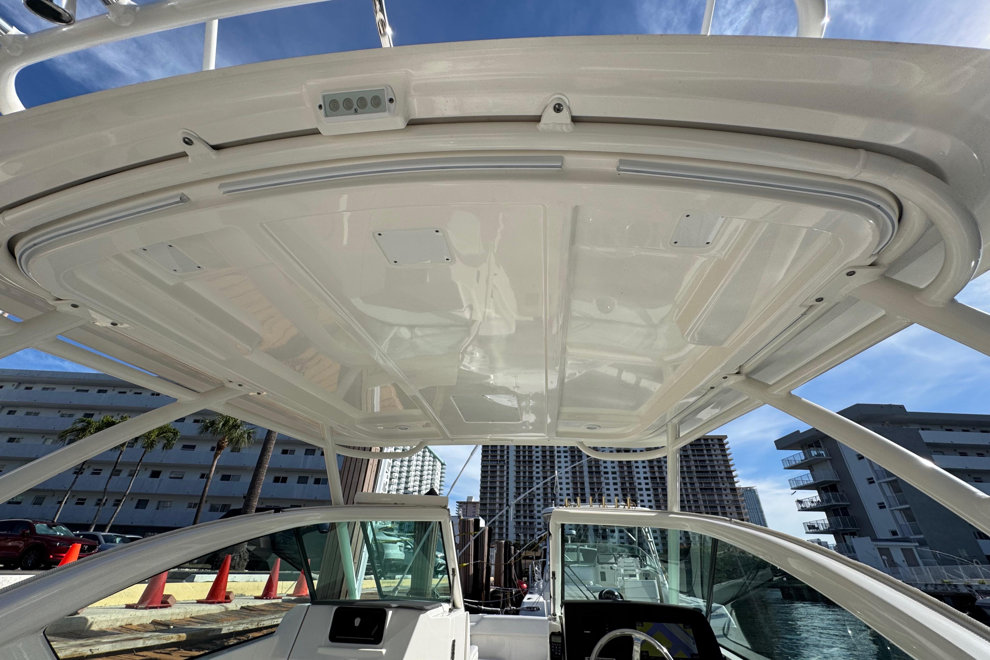 2022 Pursuit DC 266 Dual Console boat interior with hardtop, docked near urban buildings.