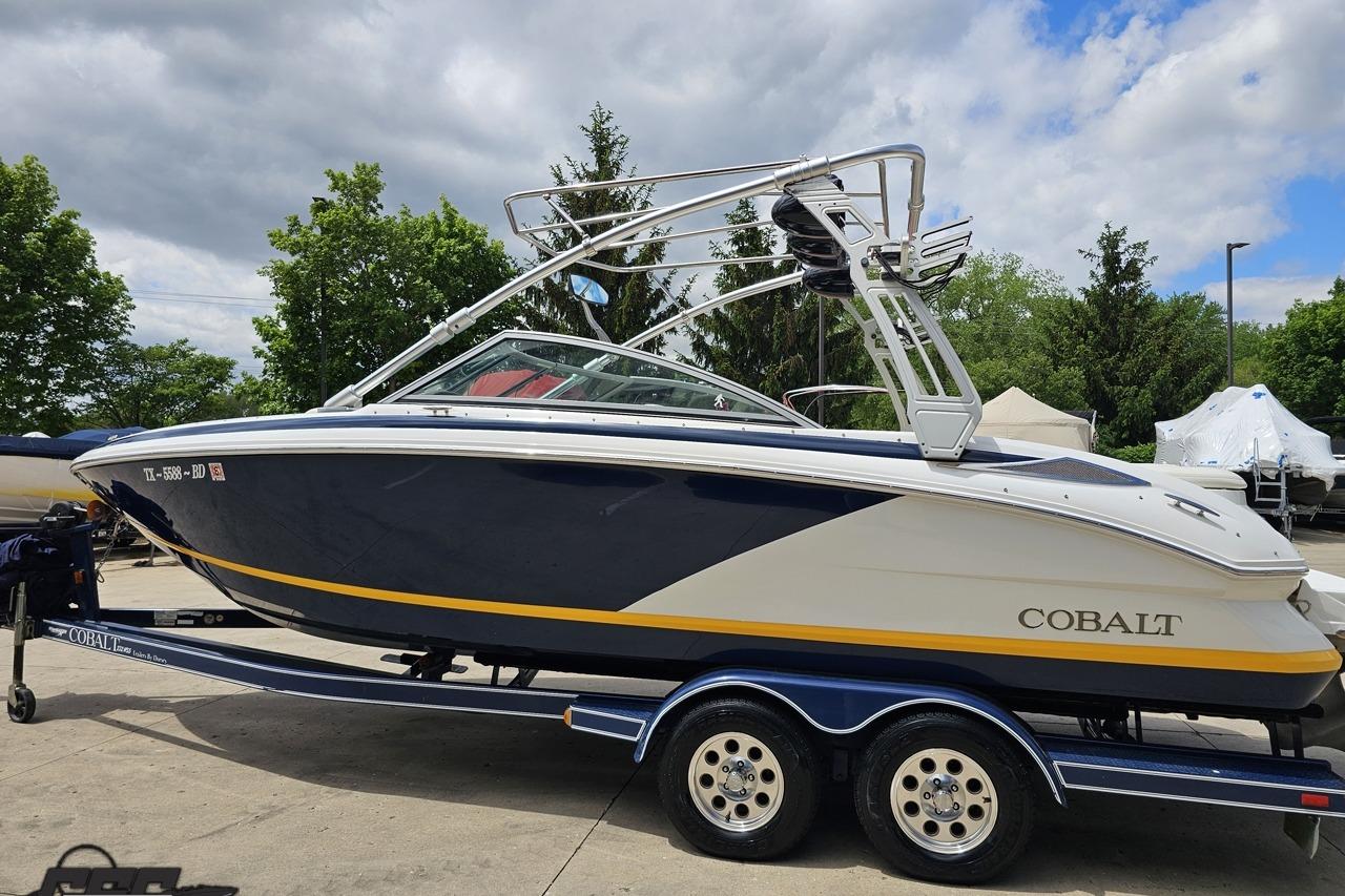 2010 Cobalt 232 WSS boat on trailer, parked outdoors under cloudy sky.