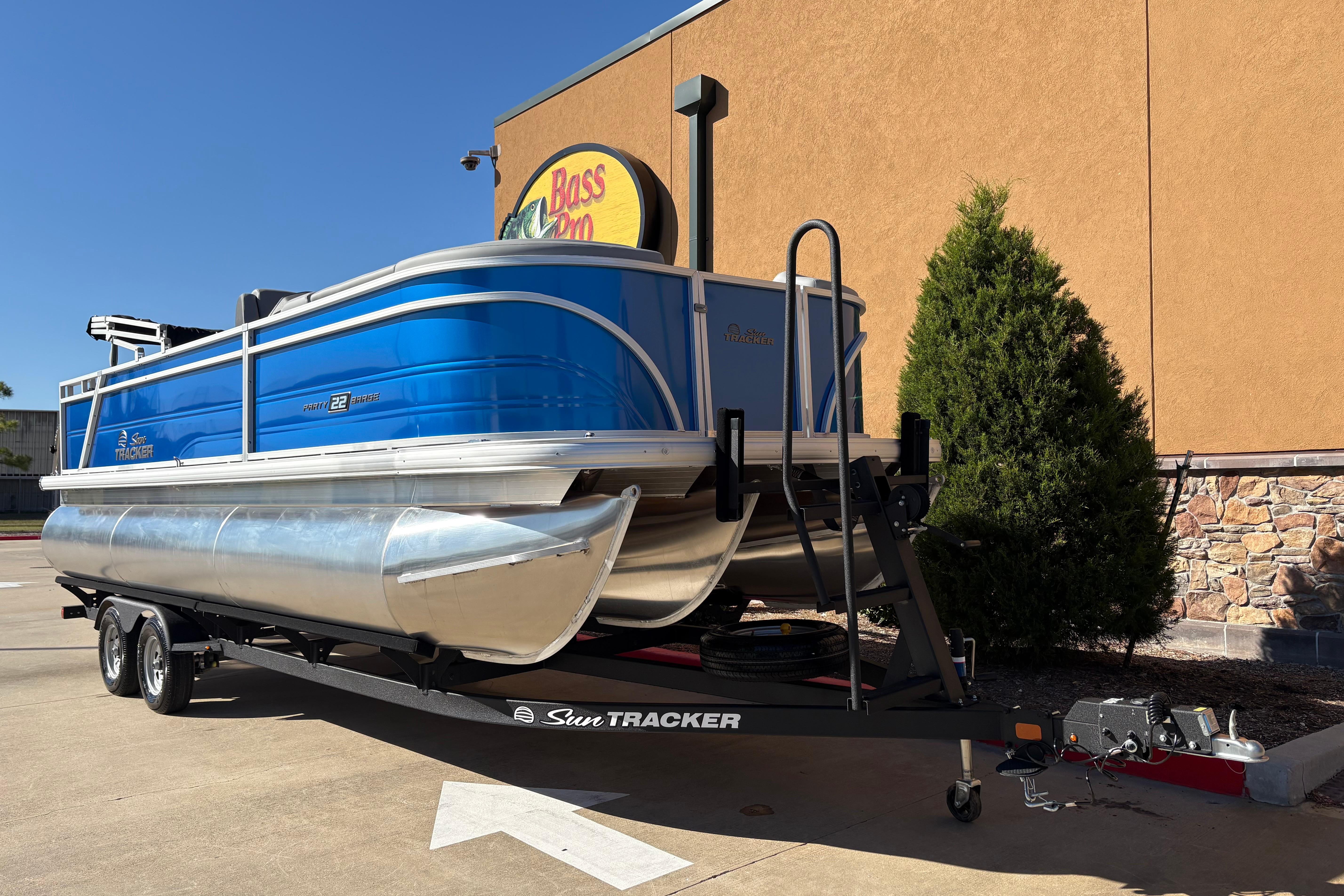 2026 Sun Tracker Party Barge 22 RF XP3 pontoon boat on trailer outside Bass Pro.