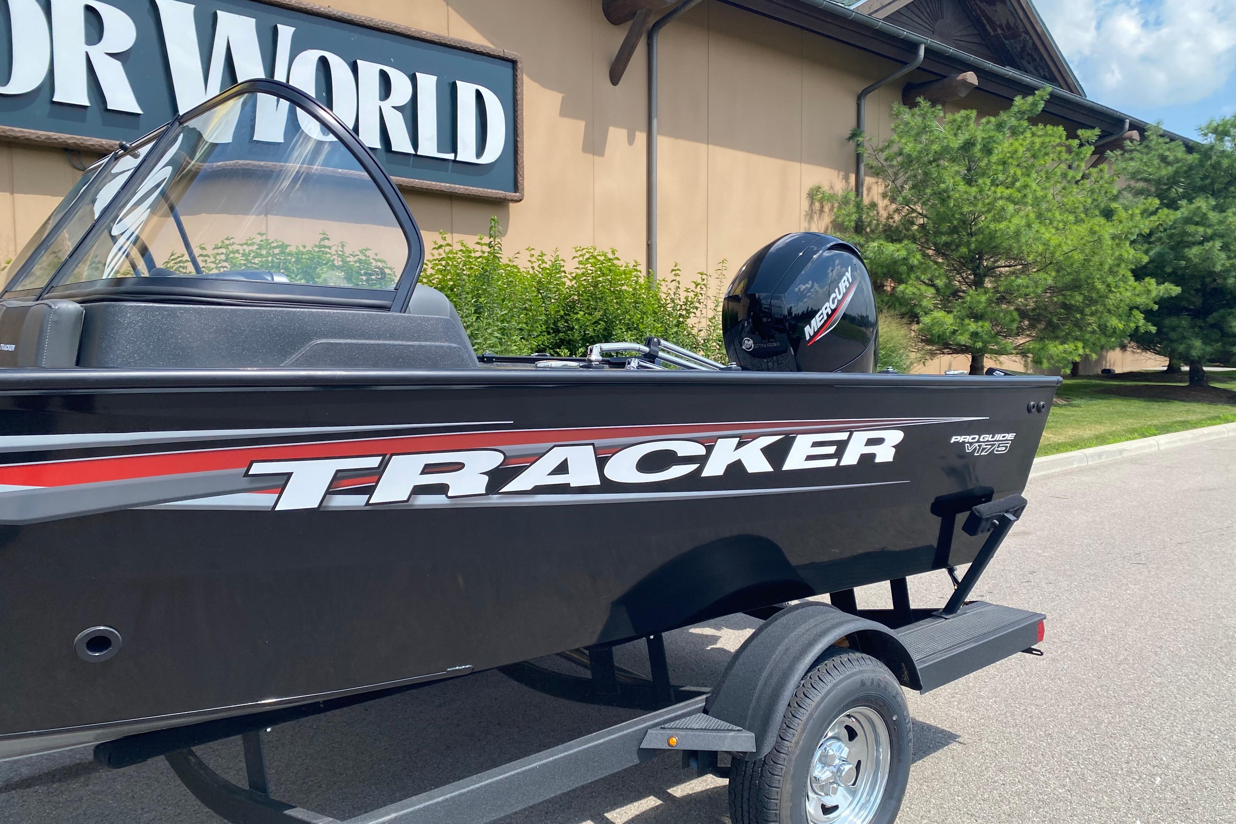 2026 Tracker Pro Guide V-175 Combo boat on trailer outside a building.