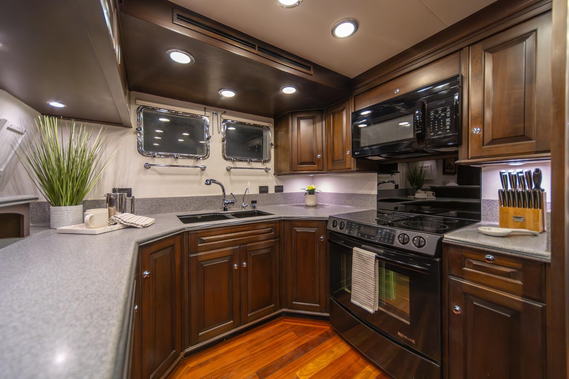 Luxurious kitchen in 2004 Northern Marine 80' Tri-Deck Expedition yacht, featuring modern appliances and elegant cabinetry.
