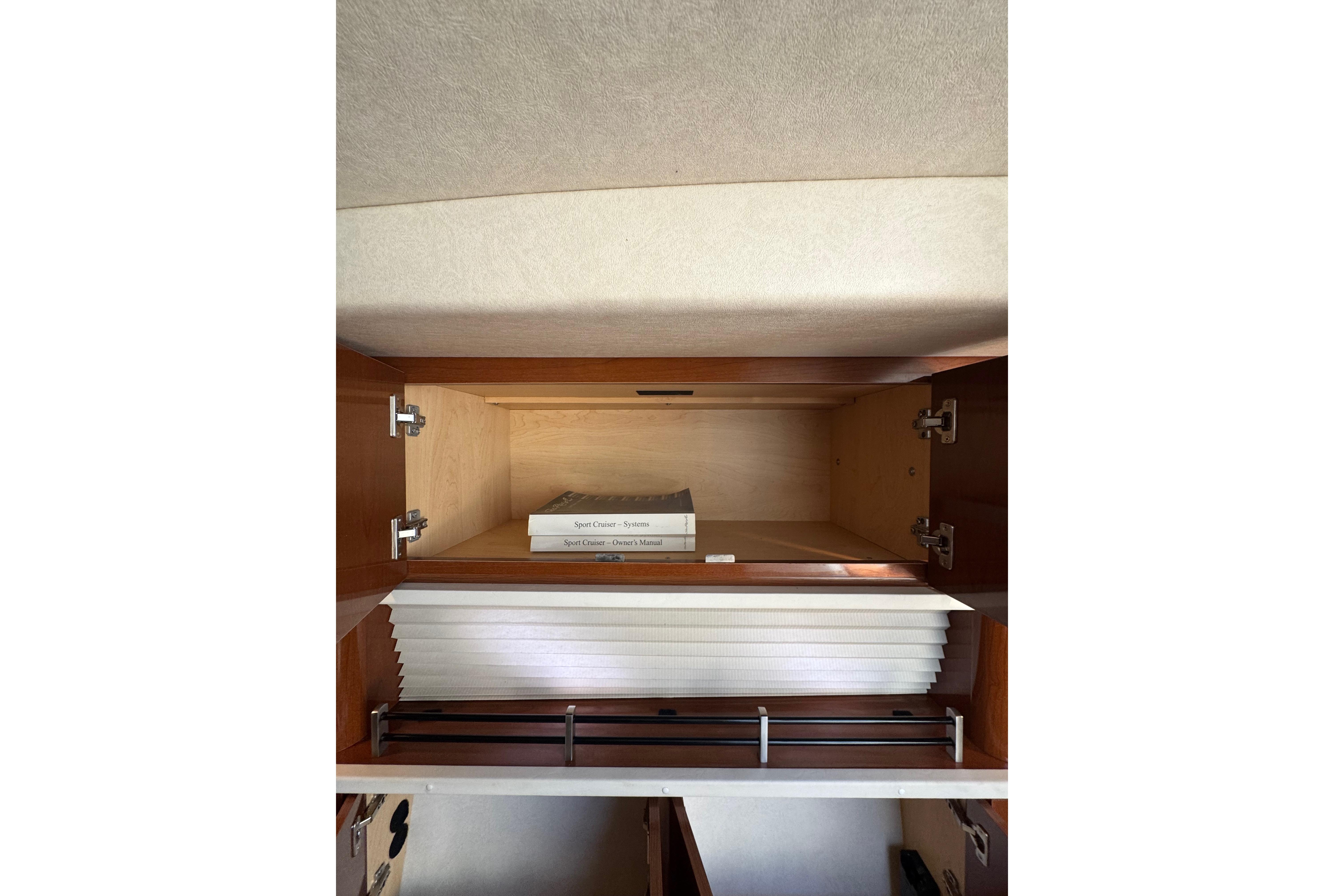 Interior cabinet of 2010 Searay 330 Sundancer with manuals and storage space.