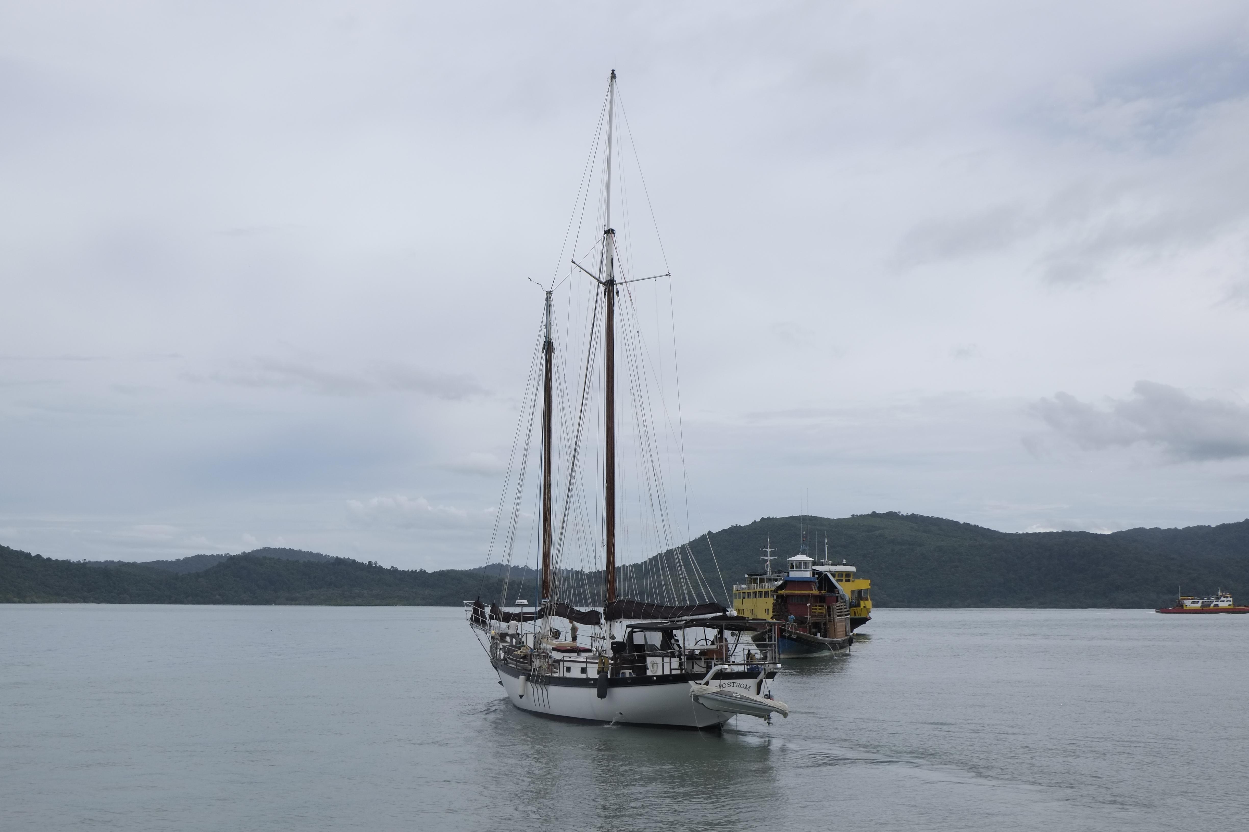 Custom Bud Macintosh schooner sailing in calm waters, 2006 model, with distant hills in background.