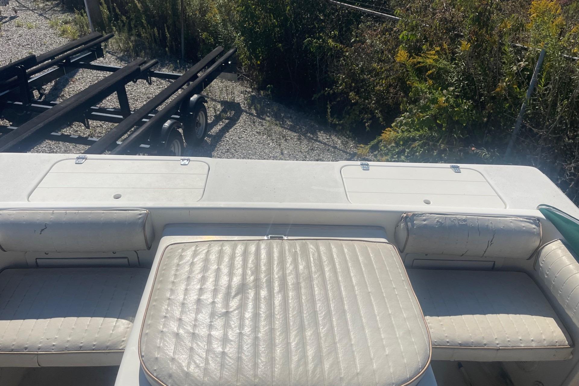Rear view of a 2000 Seamaster 2388 WA boat with worn white seating.