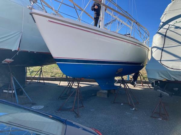 1989 Catalina 30 sailboat on stands, white hull with blue bottom, outdoors.