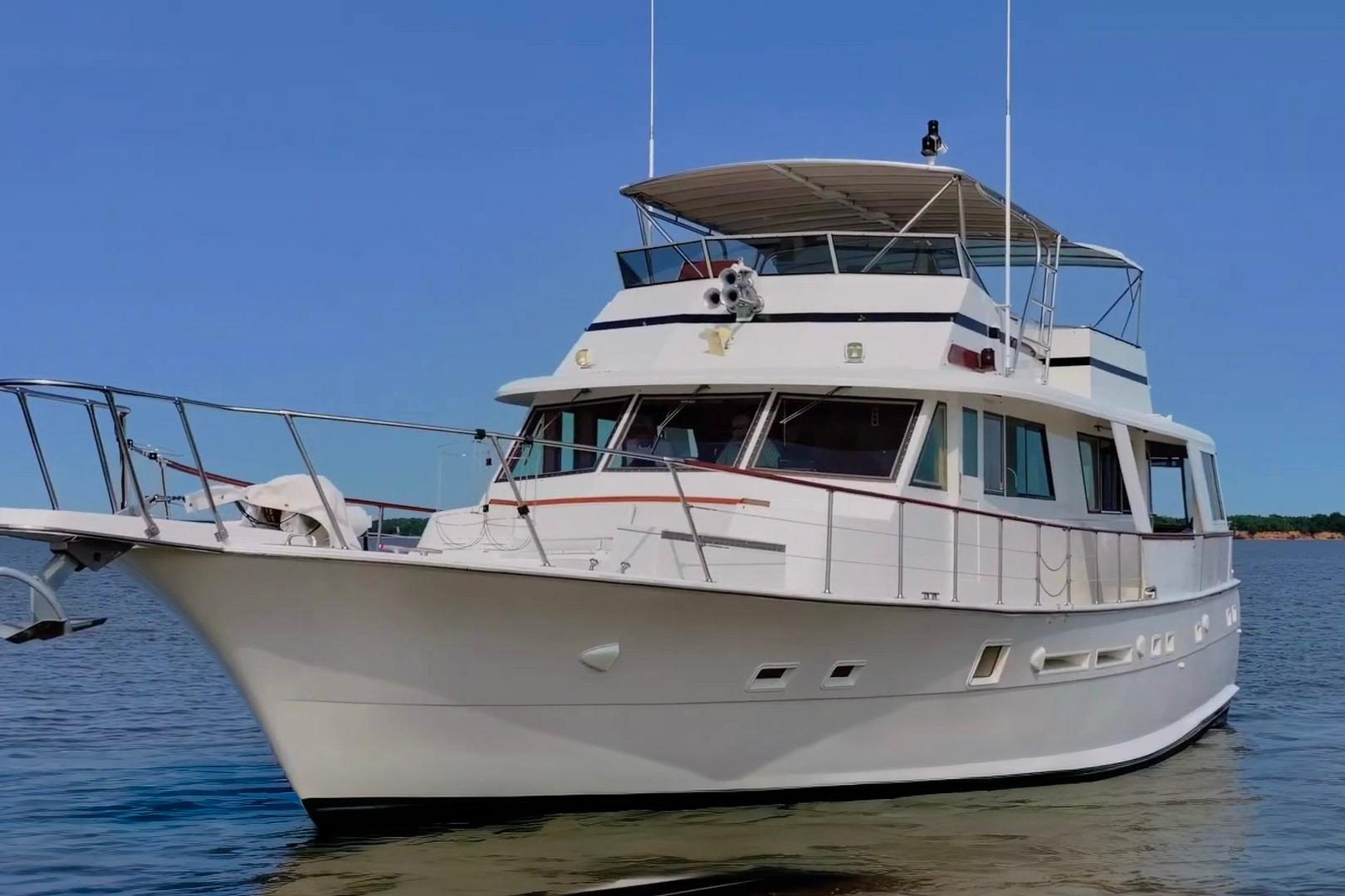 1980 Hatteras 70 Motor Yacht on calm water under clear blue sky.