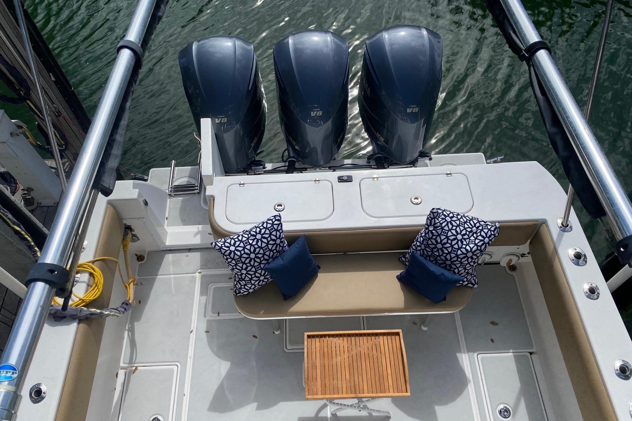2008 Contender 38 Express boat with triple engines and cushioned seating area.
