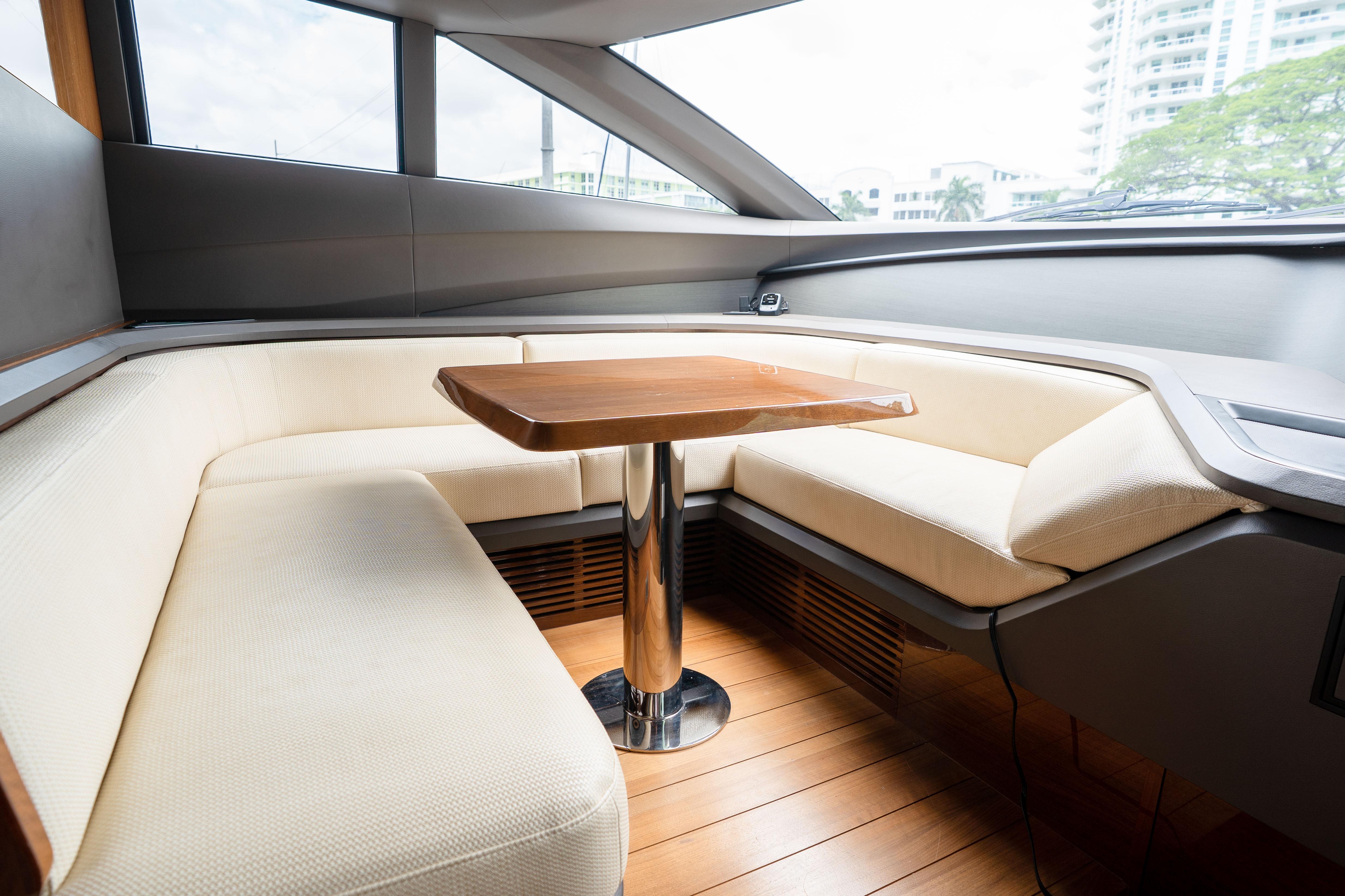 Luxurious interior of 2020 Princess Y85 yacht with elegant seating and wooden table.