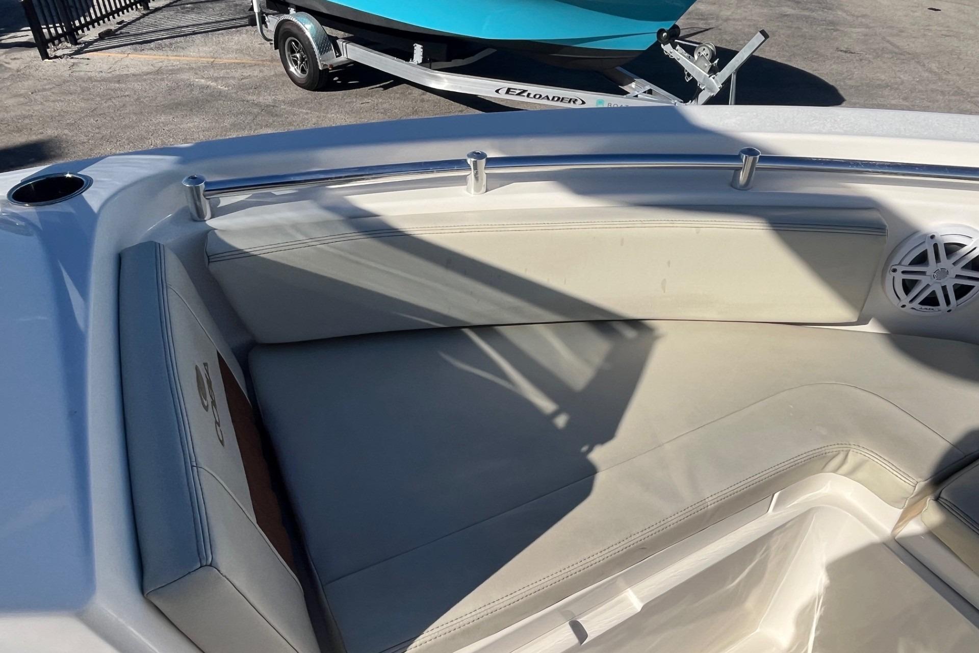 2023 Cobia 220 Dual Console boat interior with cushioned seating and speaker.