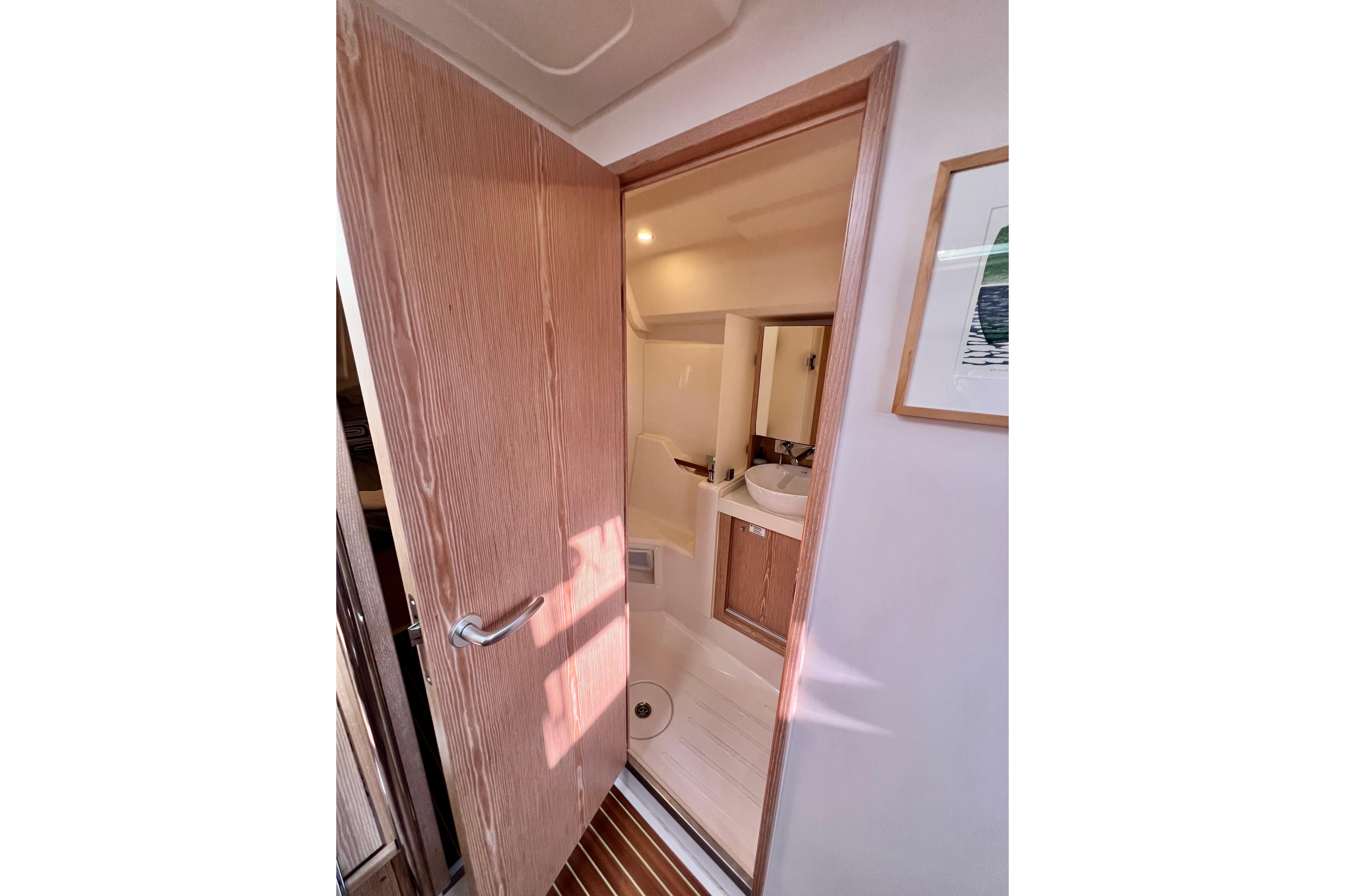 Interior view of 2016 Hanse 455 yacht bathroom with wooden door and modern sink.