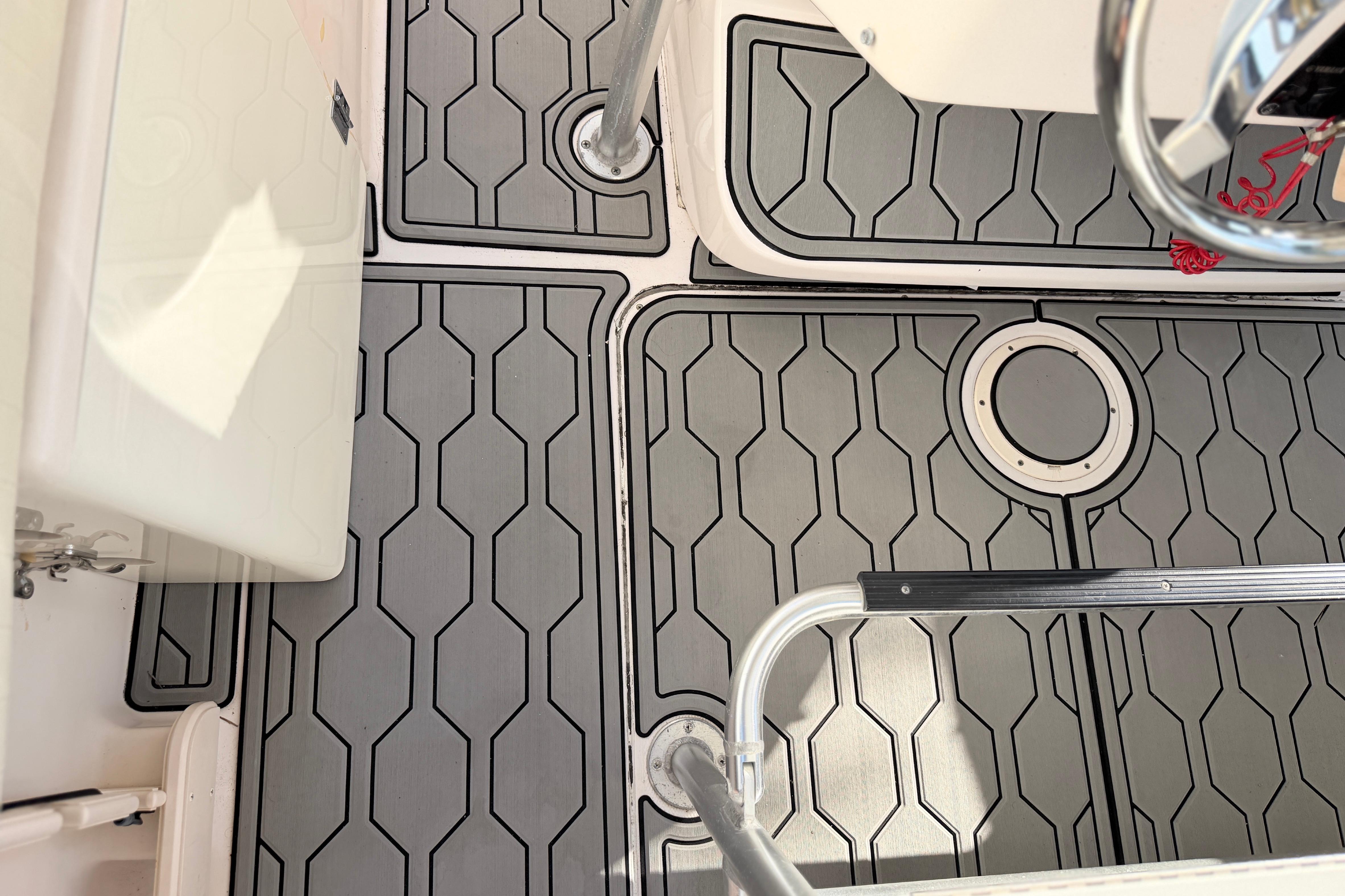 2004 Grady White 273 boat deck with hexagonal pattern flooring and metal railings.