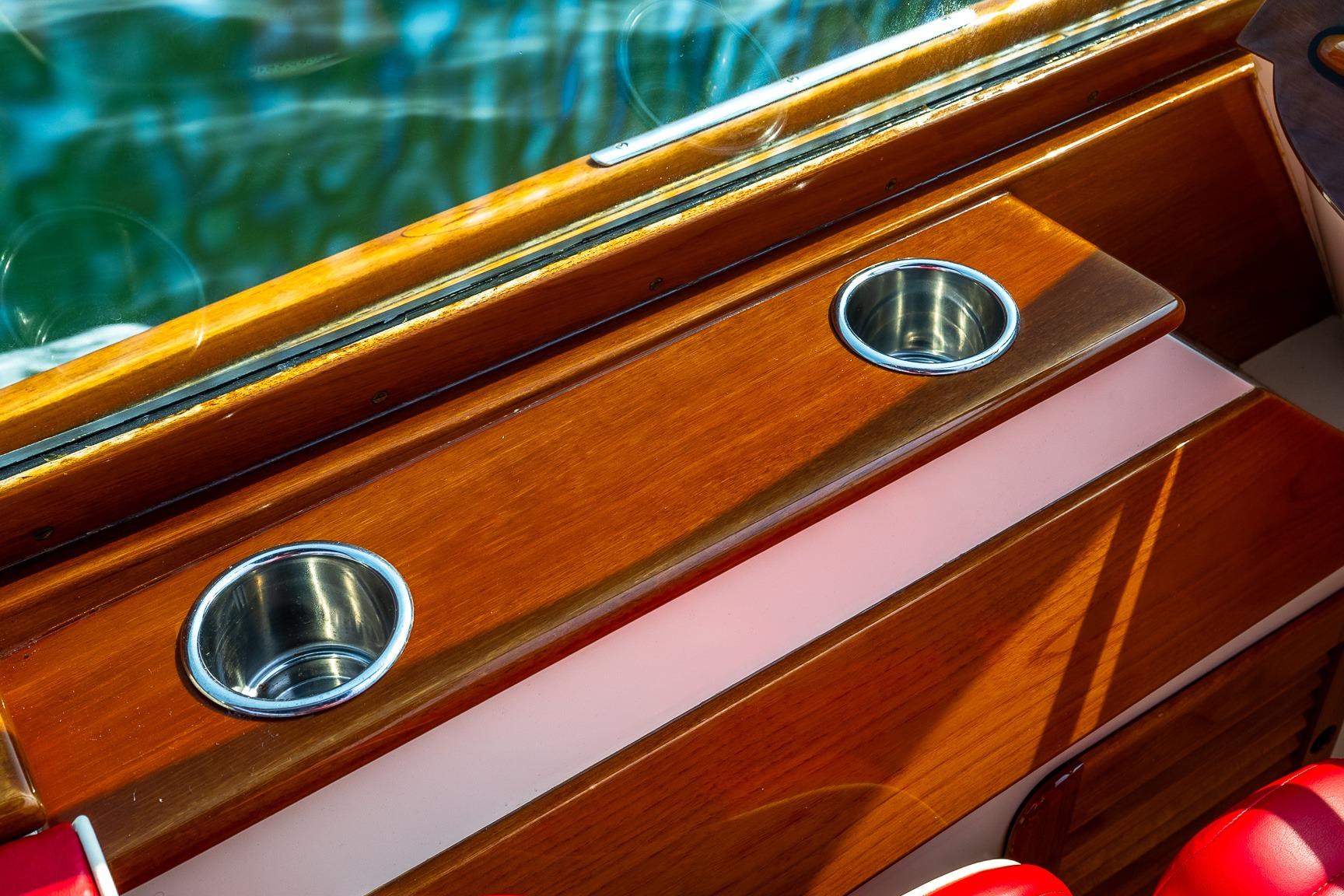 Wooden interior of 2005 Hinckley Talaria 29R boat with stainless steel cup holders.