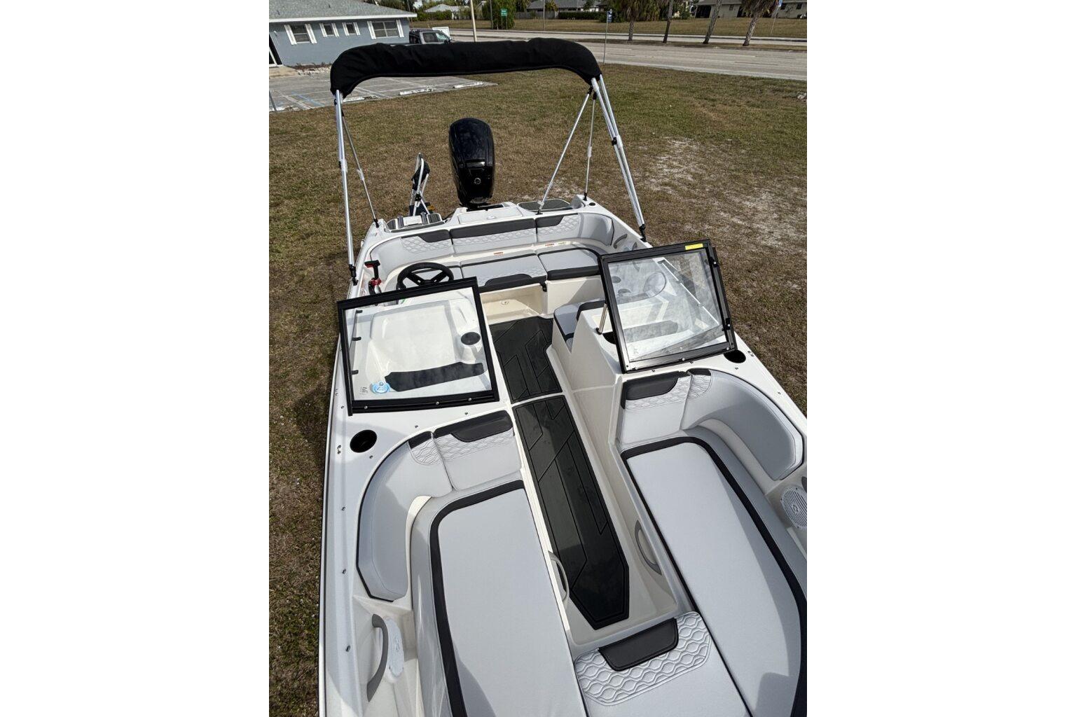 2025 Bayliner Element M17 boat with open deck and seating, parked on grass.