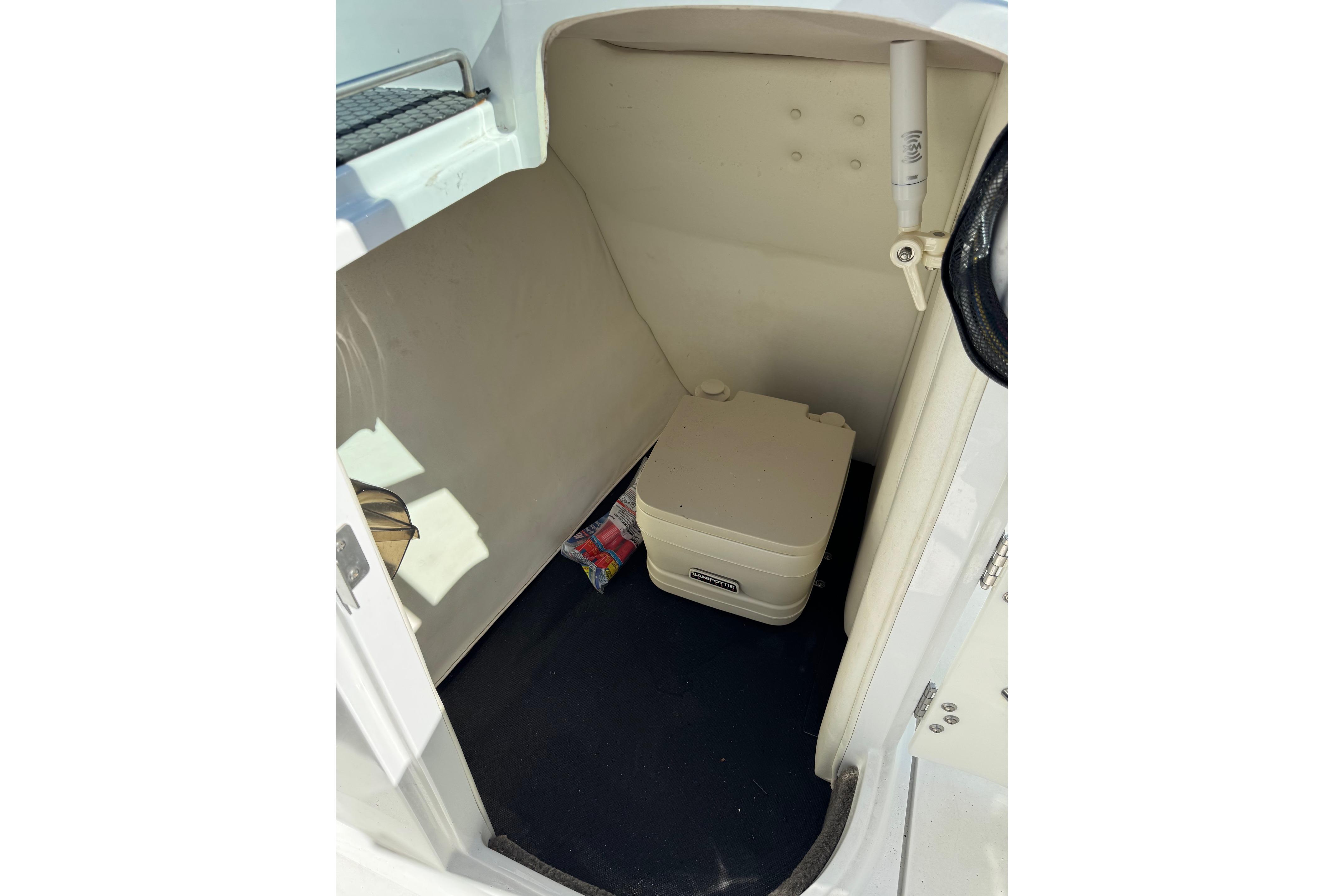 2005 Cobalt 240 boat interior with portable toilet and storage space.