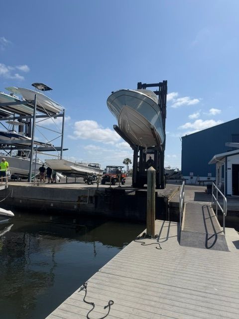 A 2024 Grady-White 251 boat is being lifted out of the water by a forklift.
