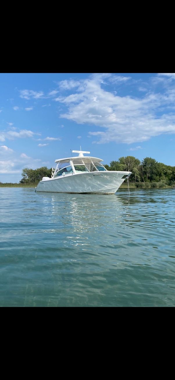 2023 Cobia 330 boat anchored on calm water.