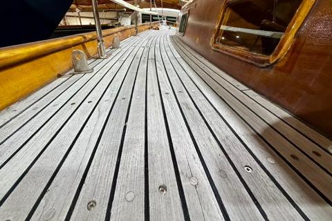 Wooden deck of a 1965 Rhodes Reliant sailboat, showcasing classic craftsmanship.