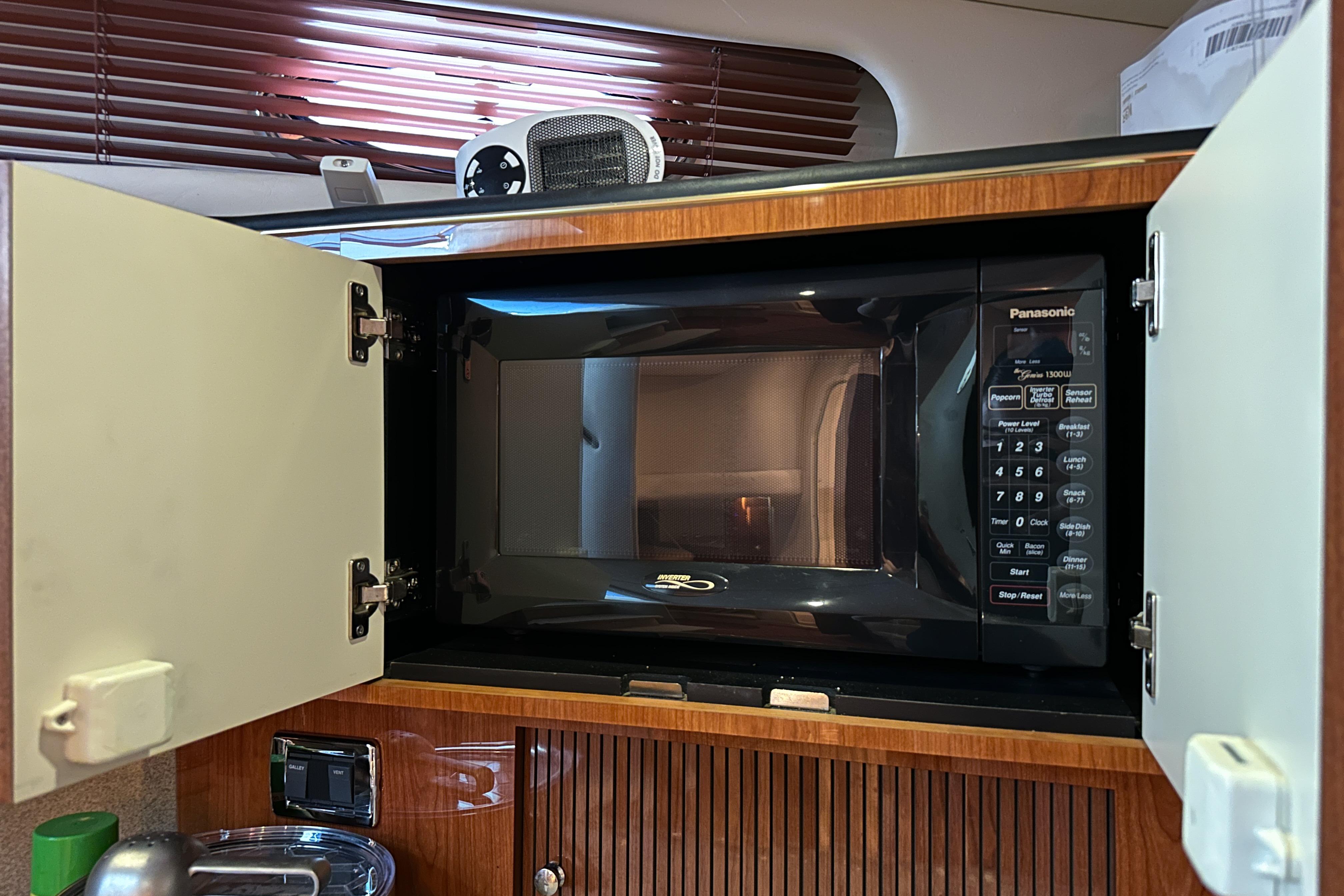 Microwave in 2001 Sea Ray 410 Sundancer yacht kitchen, with open cabinet doors.